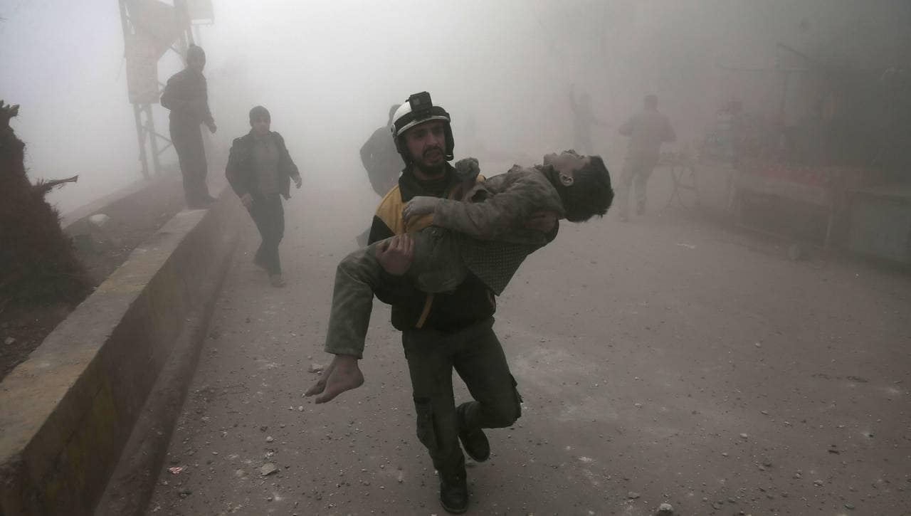 Hjelpearbeider fra De hvite hjelmene bærer bort skadet barn etter bombing i Øst-Ghouta 9.januar 2018