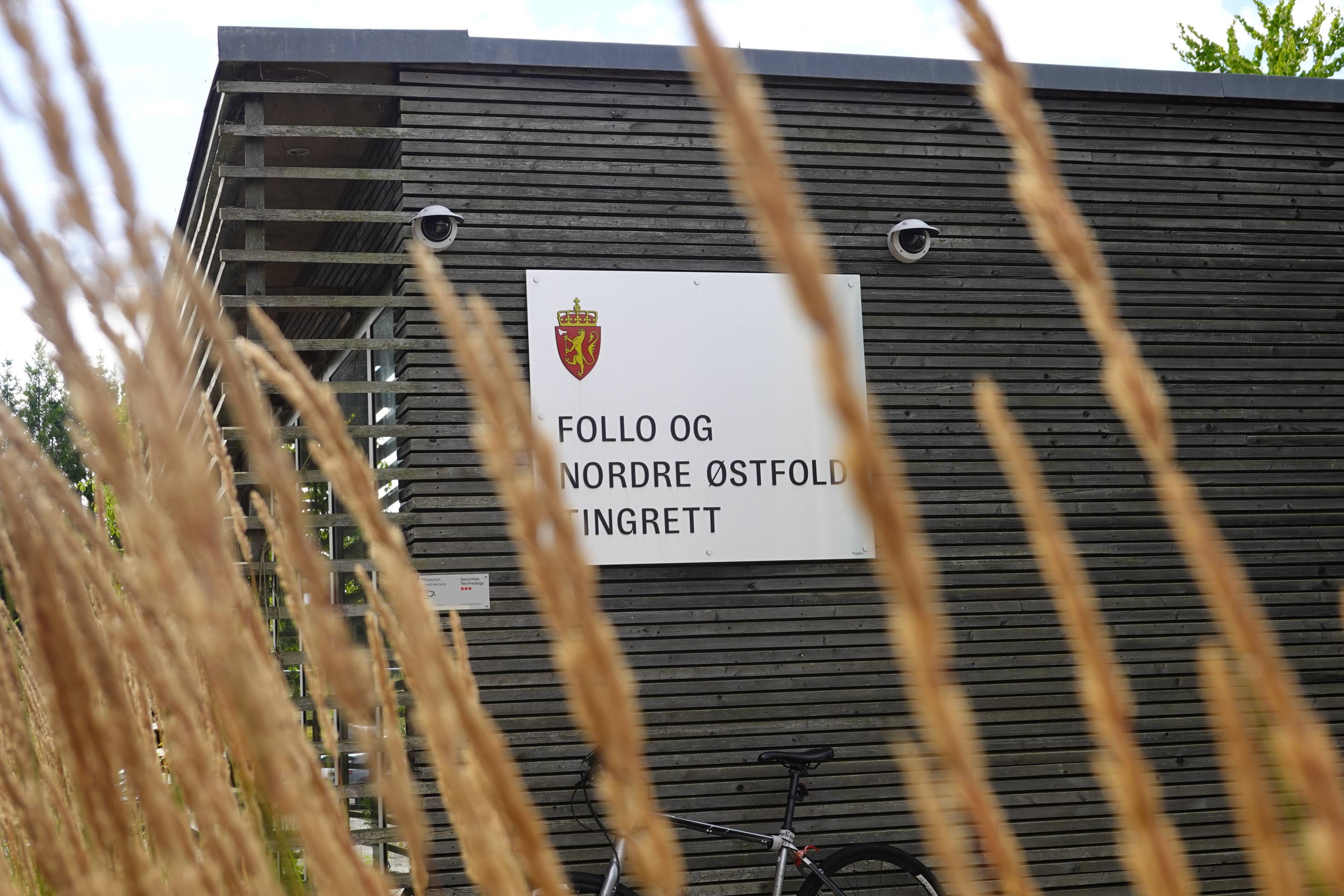 Skilt ved Follo og Nordre Østfold tingrett på en mørk trevegg. (Bildebeskrivelsen er laget av en KI-tjeneste)