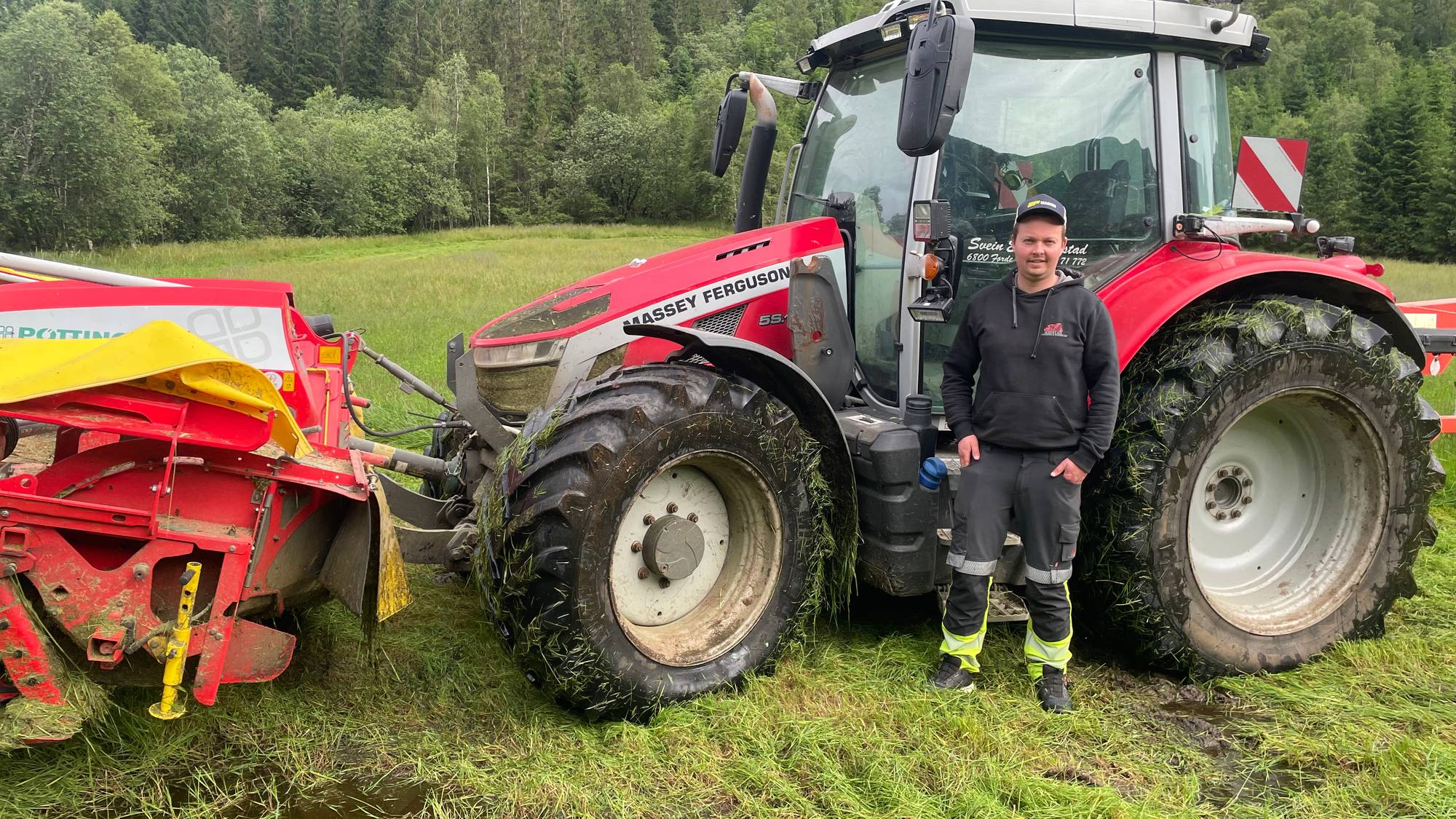 Bildet viser ein raud traktor på ein våt bø