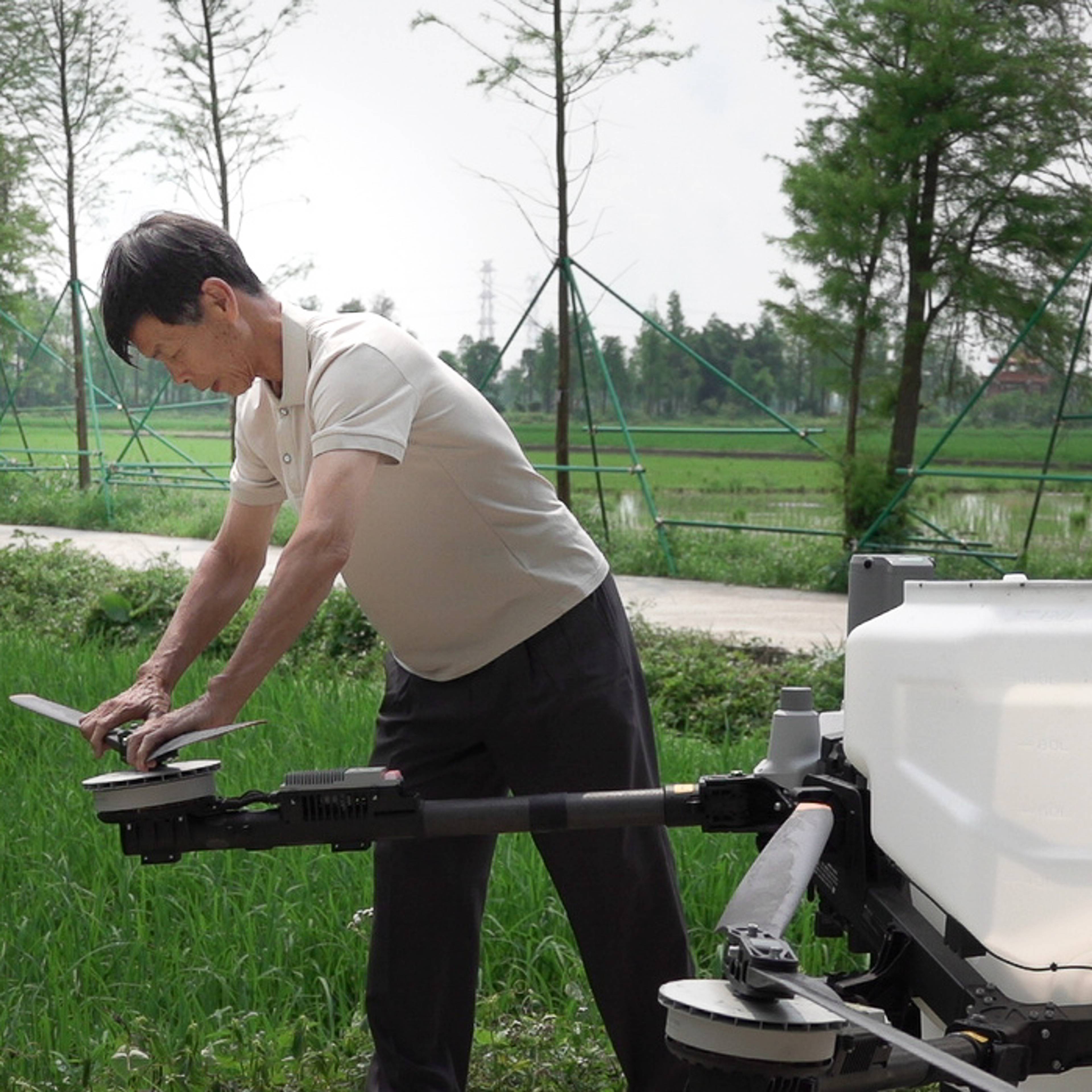 Risbonde Li Yongxiang setter på en vinge på en drone