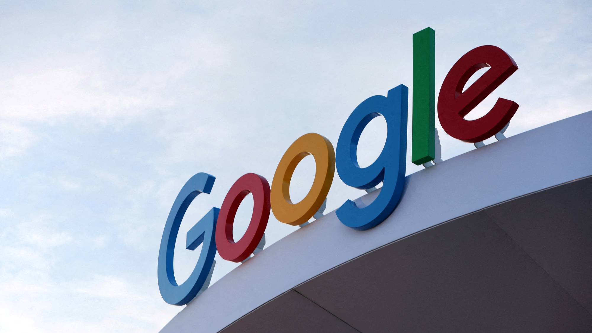 Fargerik Google-logo montert på en bygningsfasade mot en lys himmel.