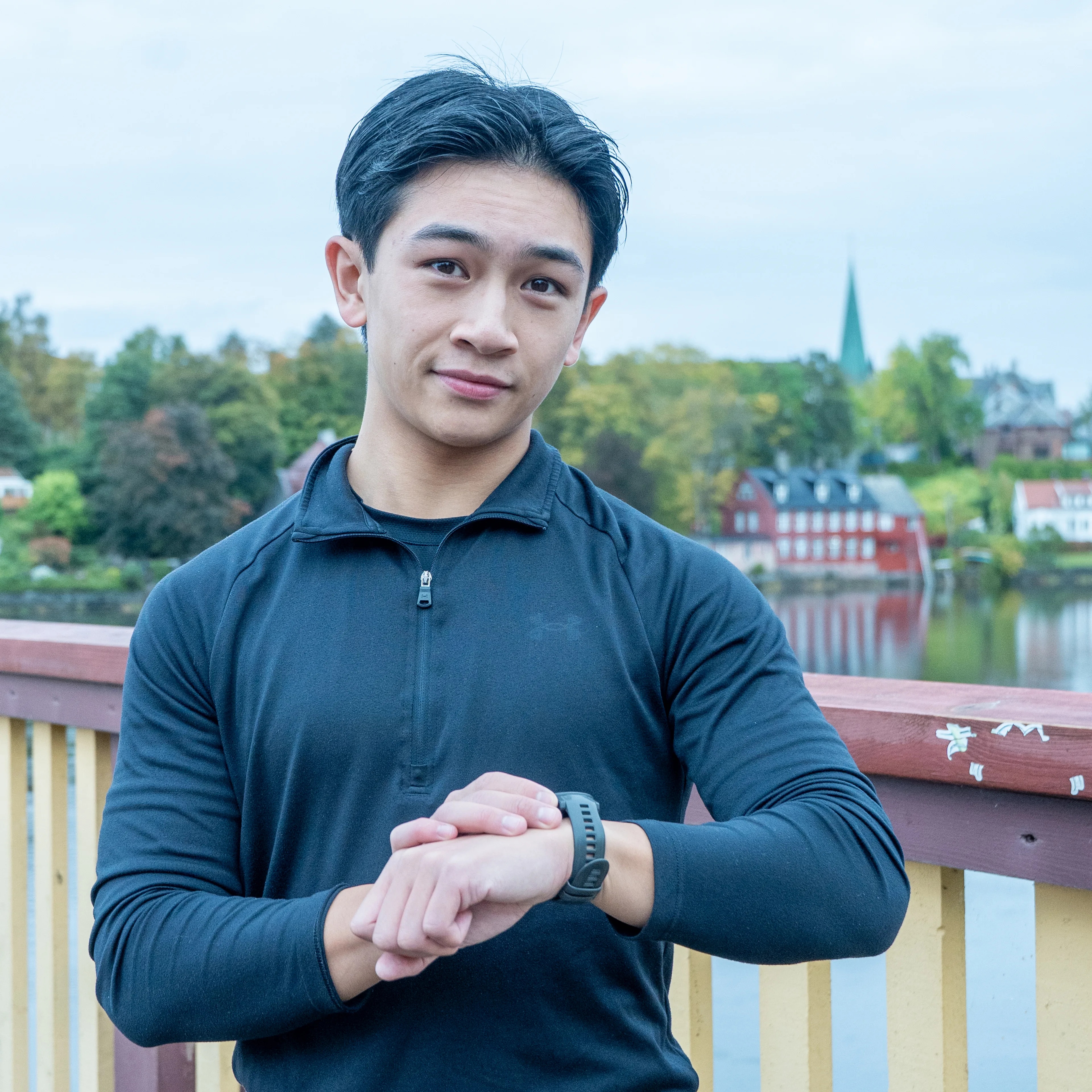 Ung mann med smartklokke ser i kamera