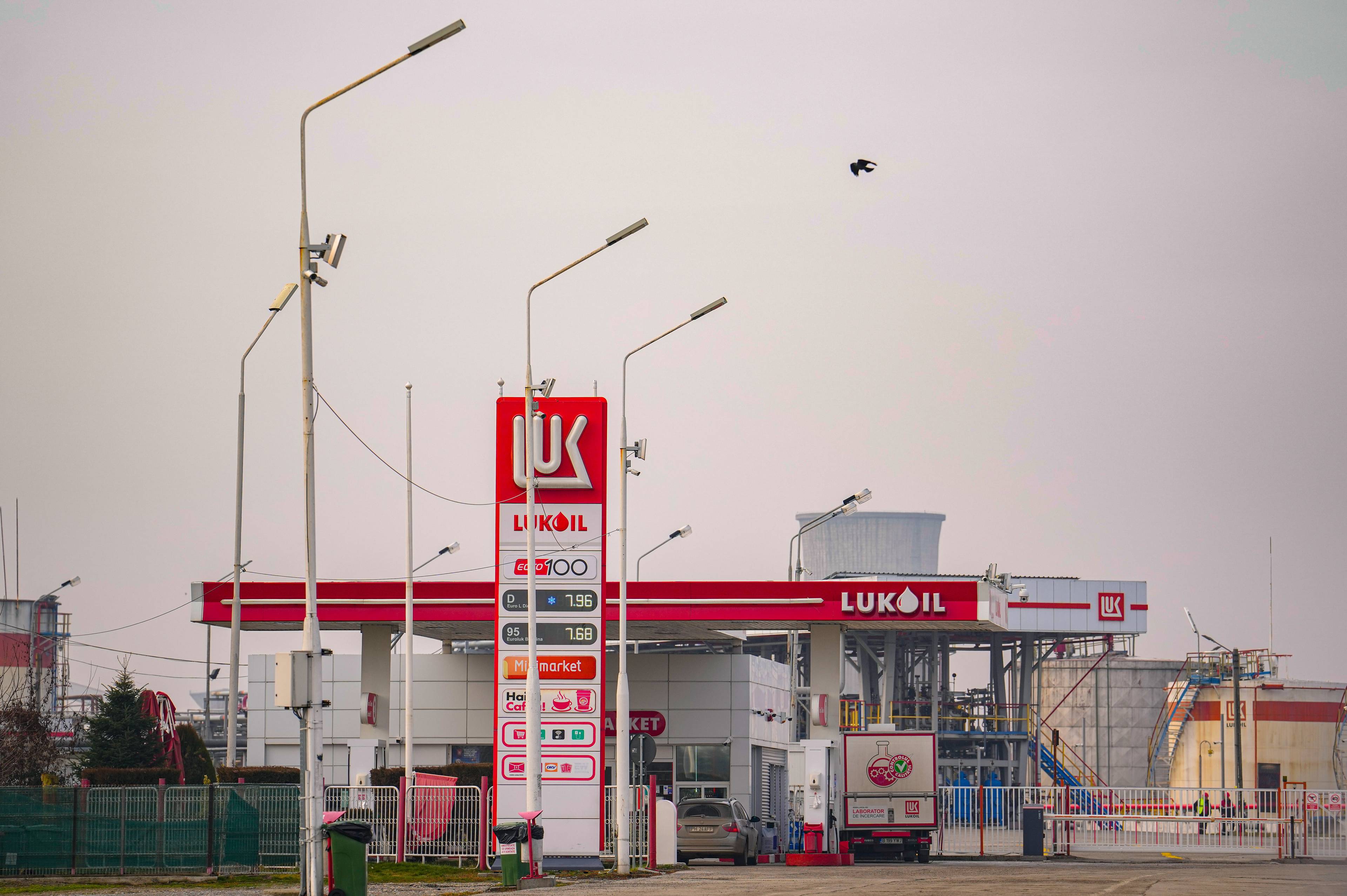 En Lukoil-bensinstasjon med prisskilt, drivstoffpumper og en lastebil på stasjonsområdet. (Bildebeskrivelsen er laget av en KI-tjeneste)
