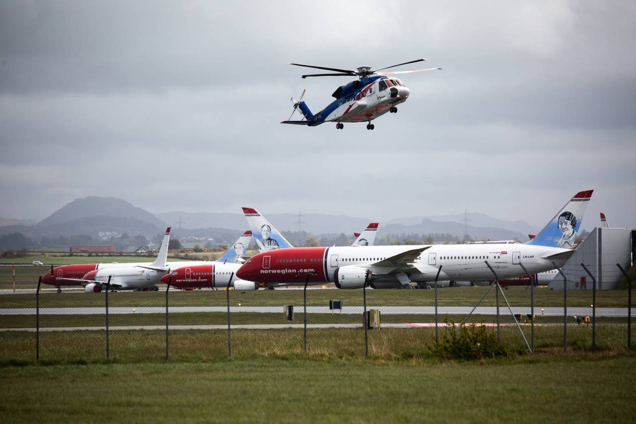 Helikopter svever over parkerte Norwegian-fly