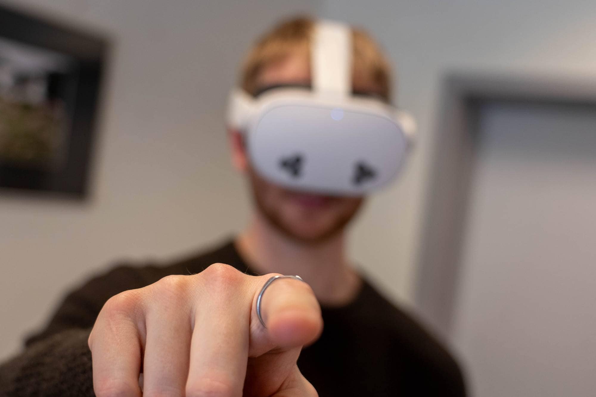 Fokus på pekefing til journalisten som peker med høyre hånd mens han har vr-headset på.