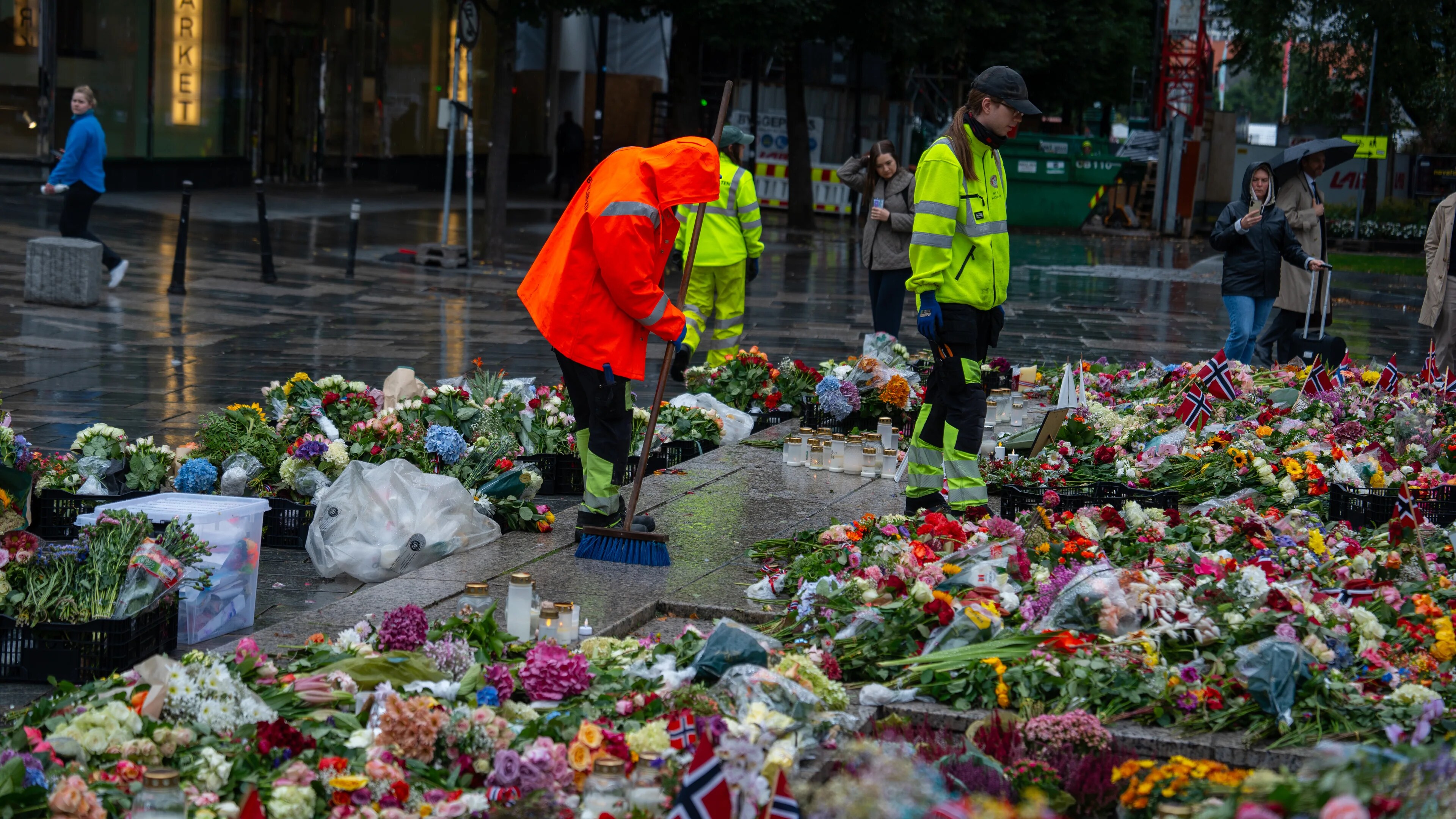 Arbeidere rydder blomster og lys som er lagt ned til minne om avdøde kong Harald. Fremdeles ligger det tusenvis av blomster rundt Den blå steinen i Bergen sentrum.