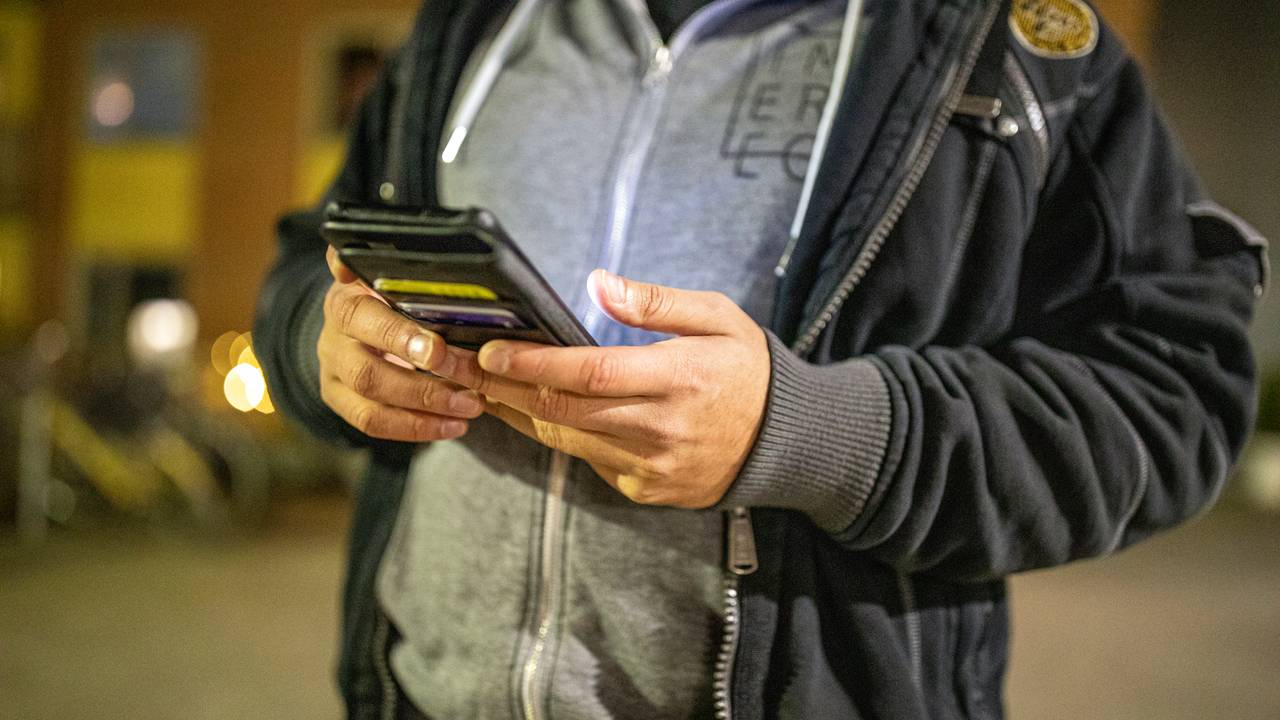 På mobilen utanfor bustadblokka