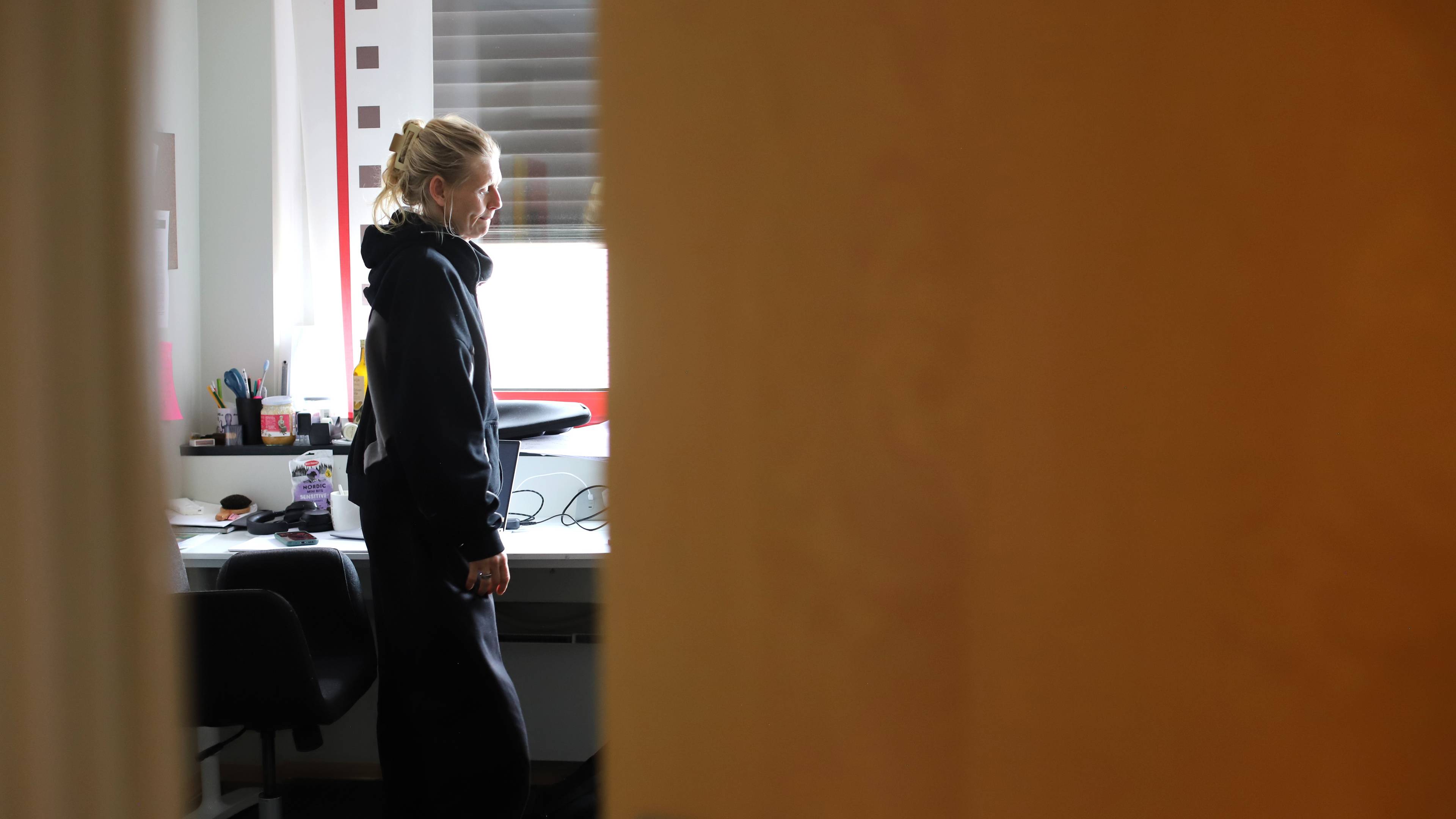 En kvinne på et kontor, sett fra en døråpning