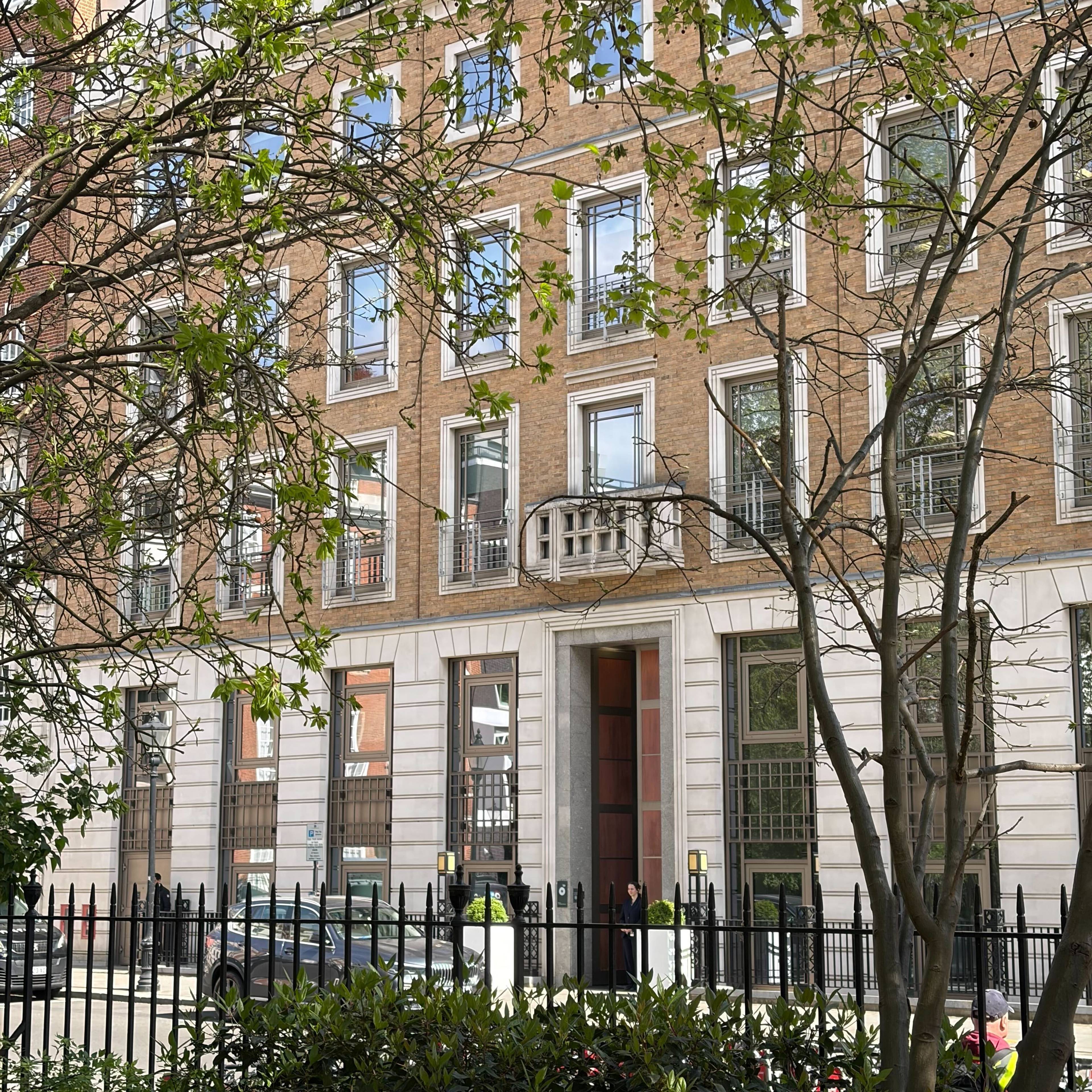 Et hvit og brunt bygg, like ved en park, med store inngangsdører, huser oljeselskapet BPs hovedkontor i London.
