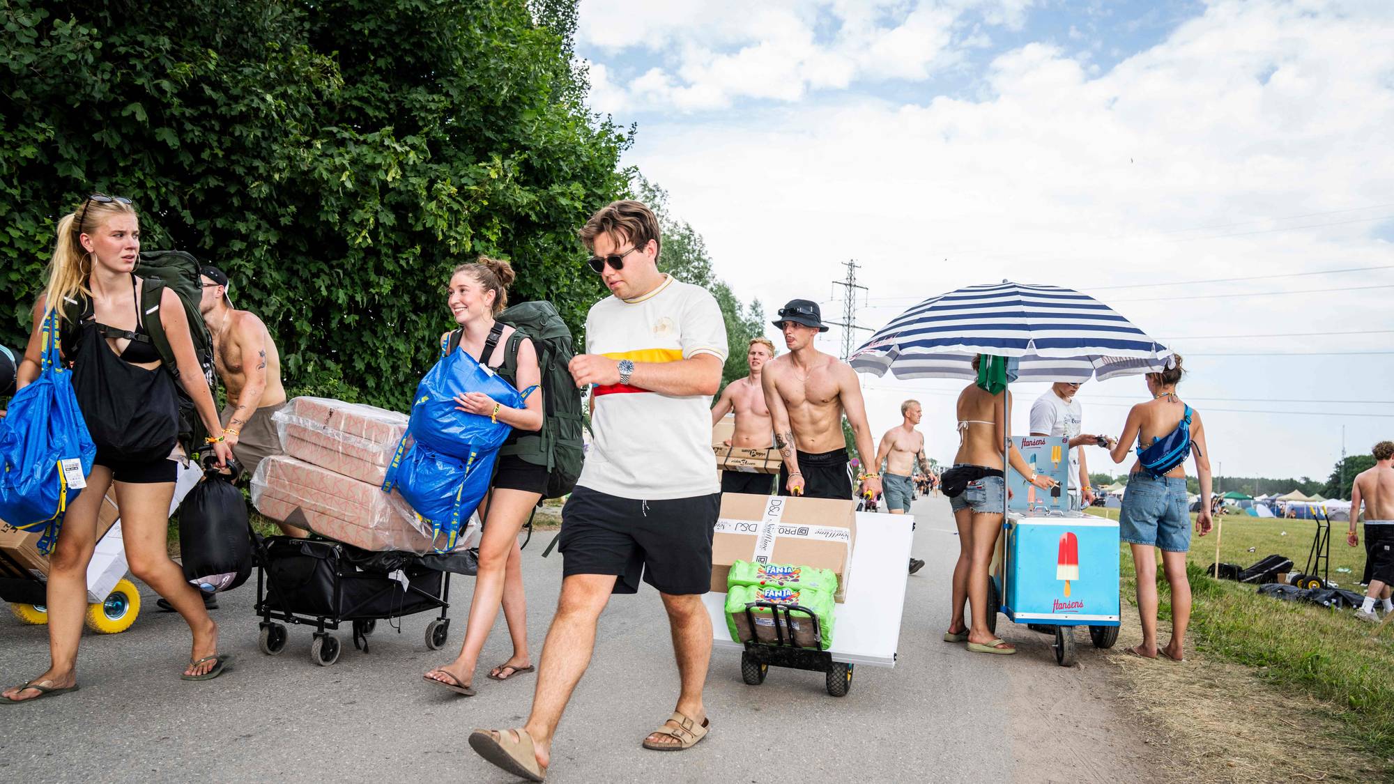 Festivaldeltakere bærer med seg utstyr inn på festivalområdet.