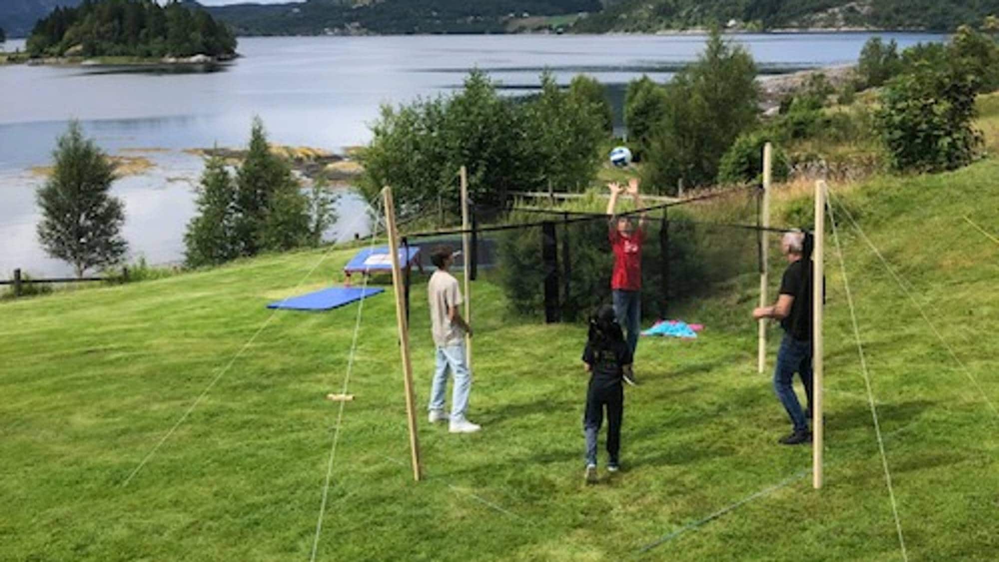 ei gruppe folk som spelar ball på ein plen 