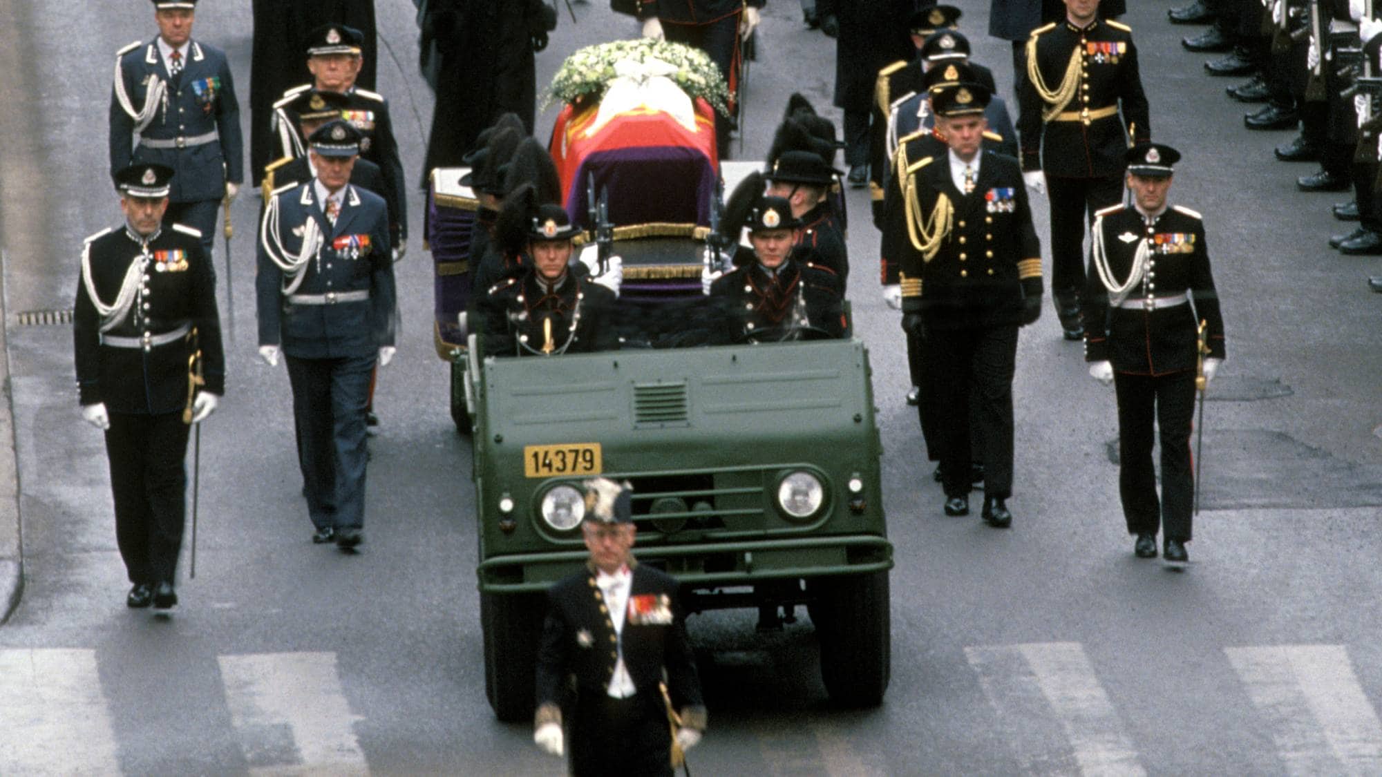 Kong Olav V begravelse. Fra prosesjonen med kong Olavs båre trukket av et militært kjøretøy fra Slottet til Oslo Domkirke.
Kongefamilien i sorg går bak båren.