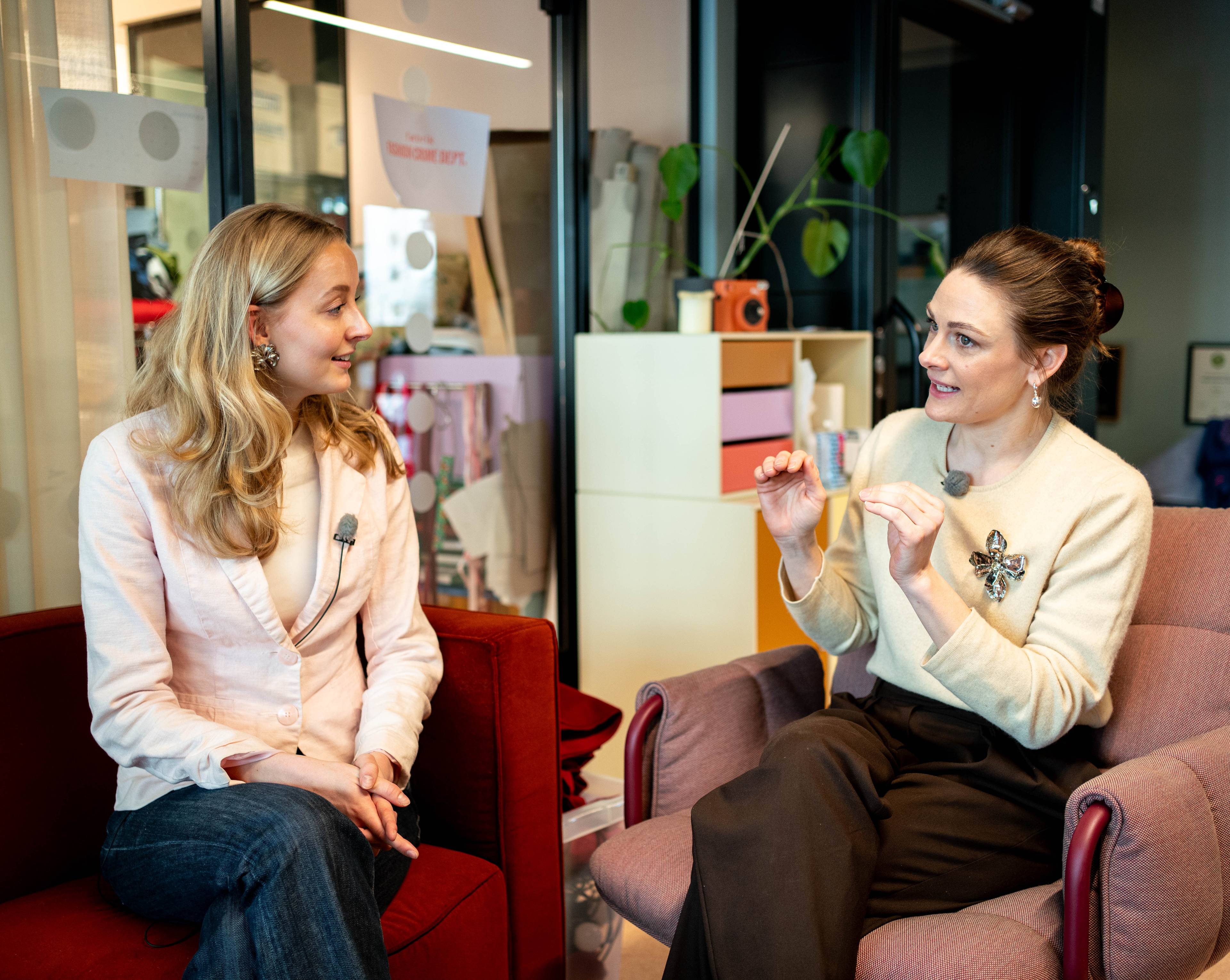 Journalist Tuva Christiansen og Jenny Skavlan sitter og prater sammen på en sofa.