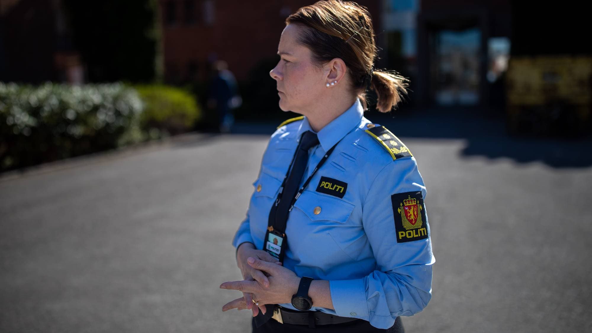 En kvinne i politiuniform ser til siden.