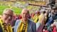 Odd Emil Ingebrigtsen / privat Ta gråhårede menn med dressjakker og gule skjerf står i Ullevaal stadion og smiler til kamera. I bakgrunn spiller Brann mot Bodø/Glimt.