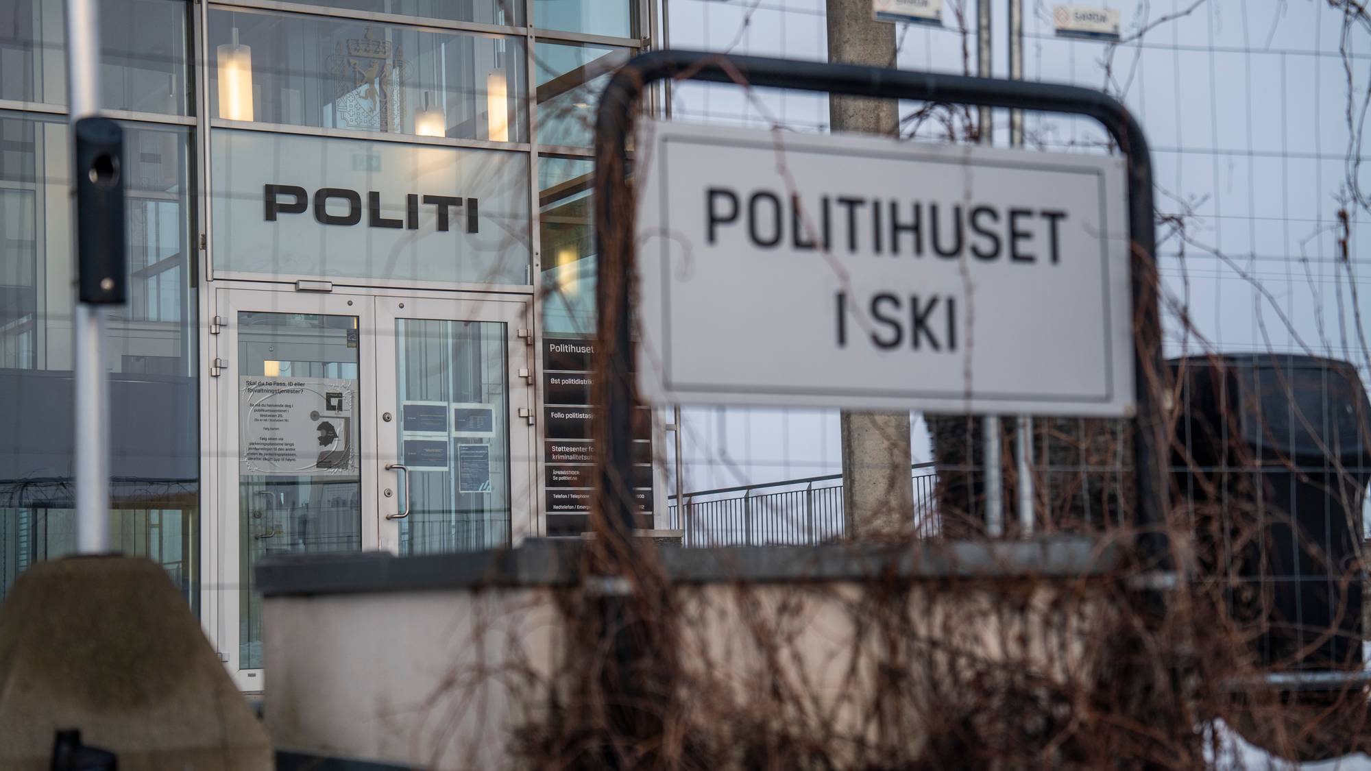 Bilde av hovedinngangen til politihuset i Ski. Fokuset er på skiltet ved veien hvor det står "Politihuset i Ski"