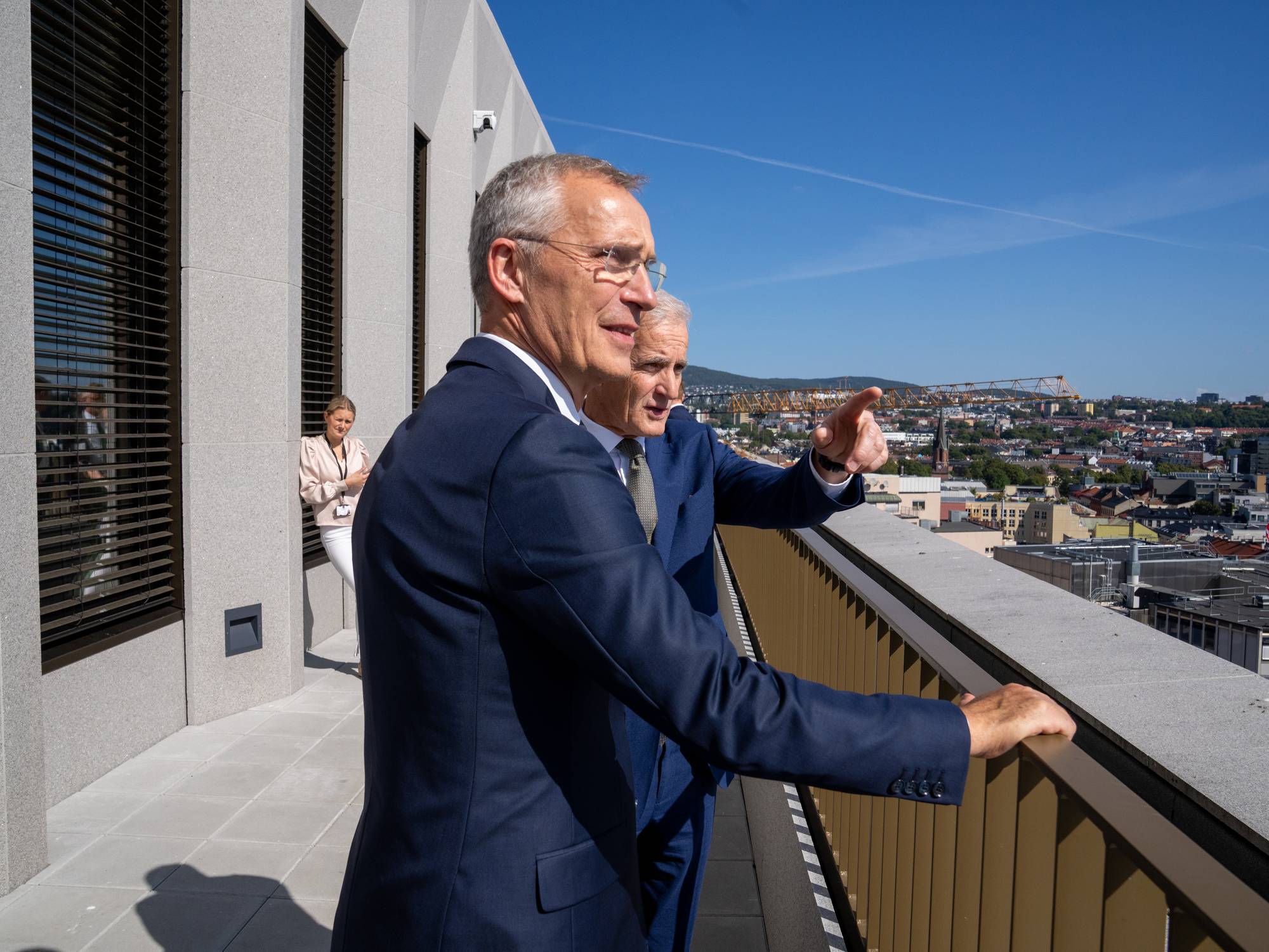 Finansminister Jens Stoltenberg og statsminister Jonas Gahr Støre intervjues før årets siste budsjettkonferanse på Statministerens kontor. Stills er tatt på forværelset til Statministerens nye kontor i D-blokka i det nye Regjeringskvartalet. Ellers er Stoltenberg og Støre på balkongen utenfor SMK. Stoltenberg viser Støre Arbeiderpartiets hovedkontor i Folketeaterbygningen på Youngstorvet, som skimtes i bakgrunnen.
