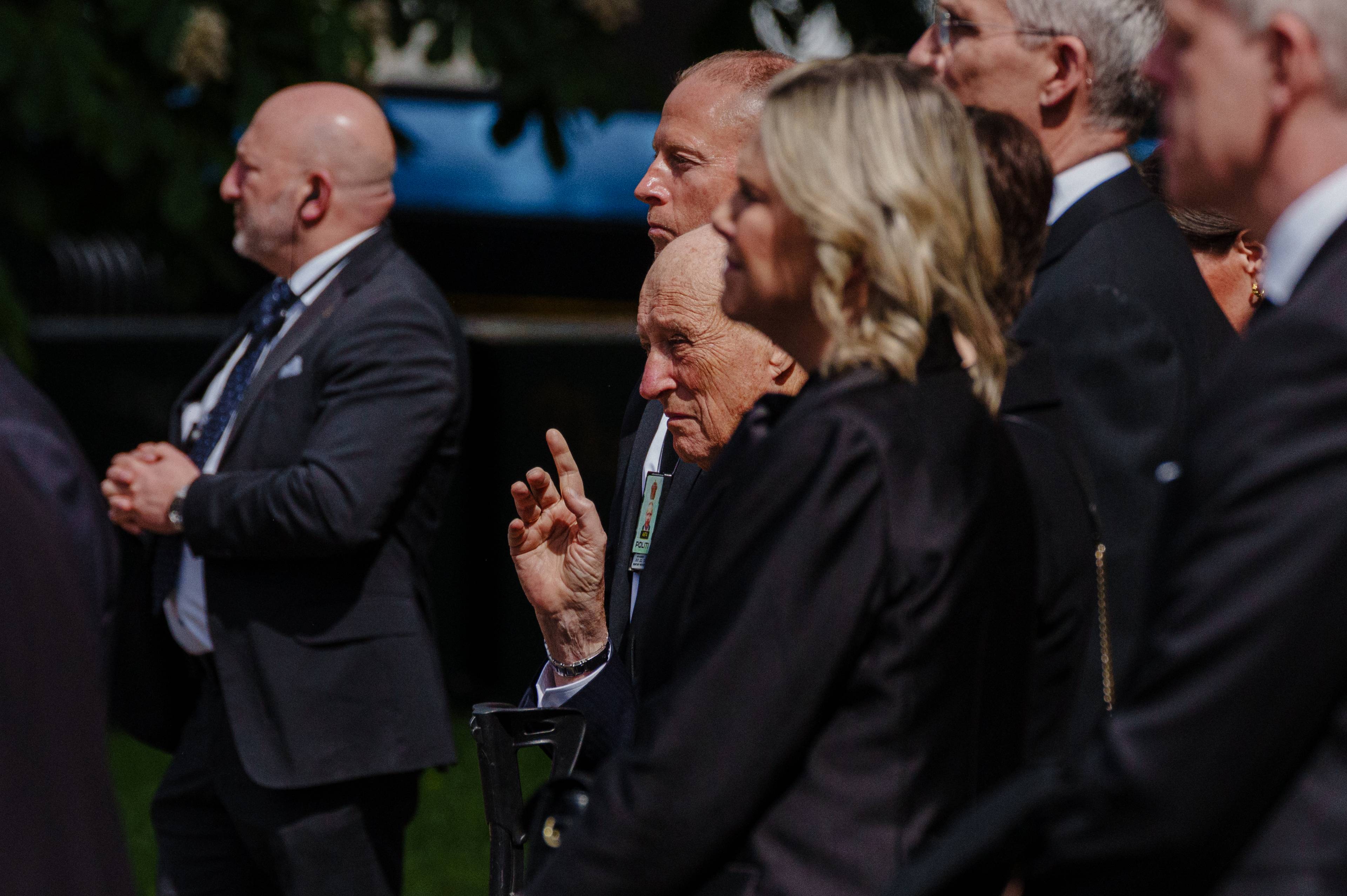 Kong Harald har et furet ansikt og holder hånden opp litt ved siden av