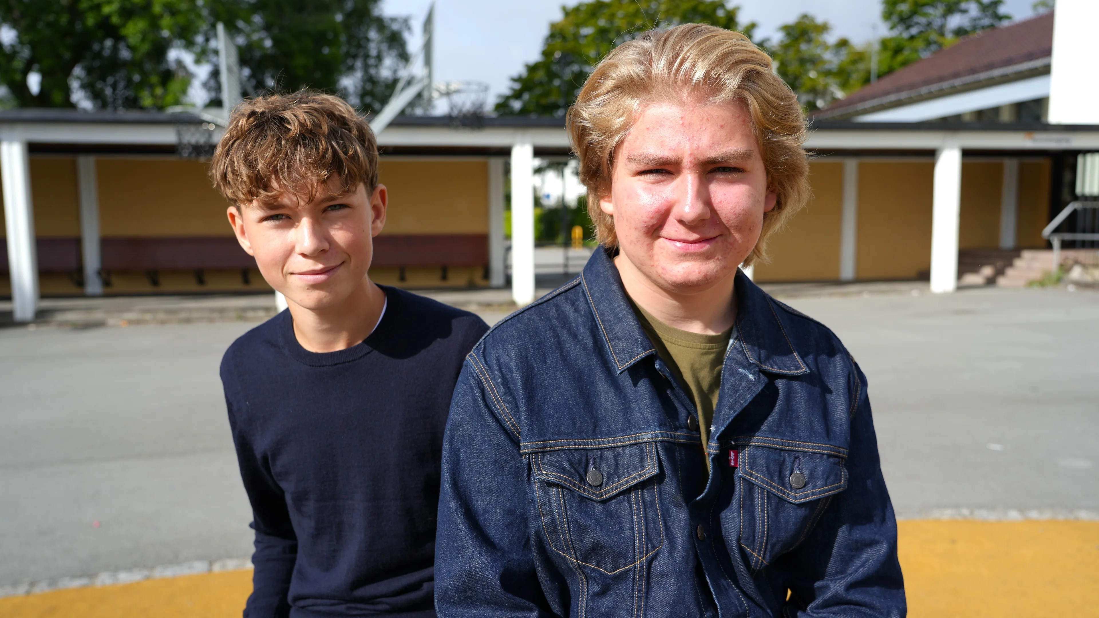 Sverre Galta og Brim Benoni-Størseth går i 10.klasse på kannik skole. Her sitter de ute i skolegården og smiler mot kamera.