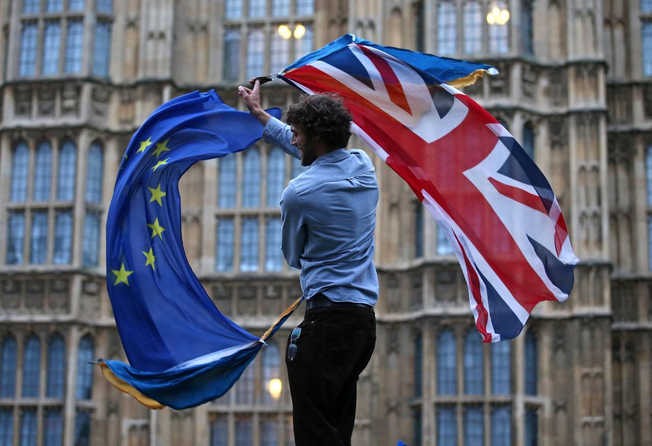 Mann med EU-flagg og britisk flagg