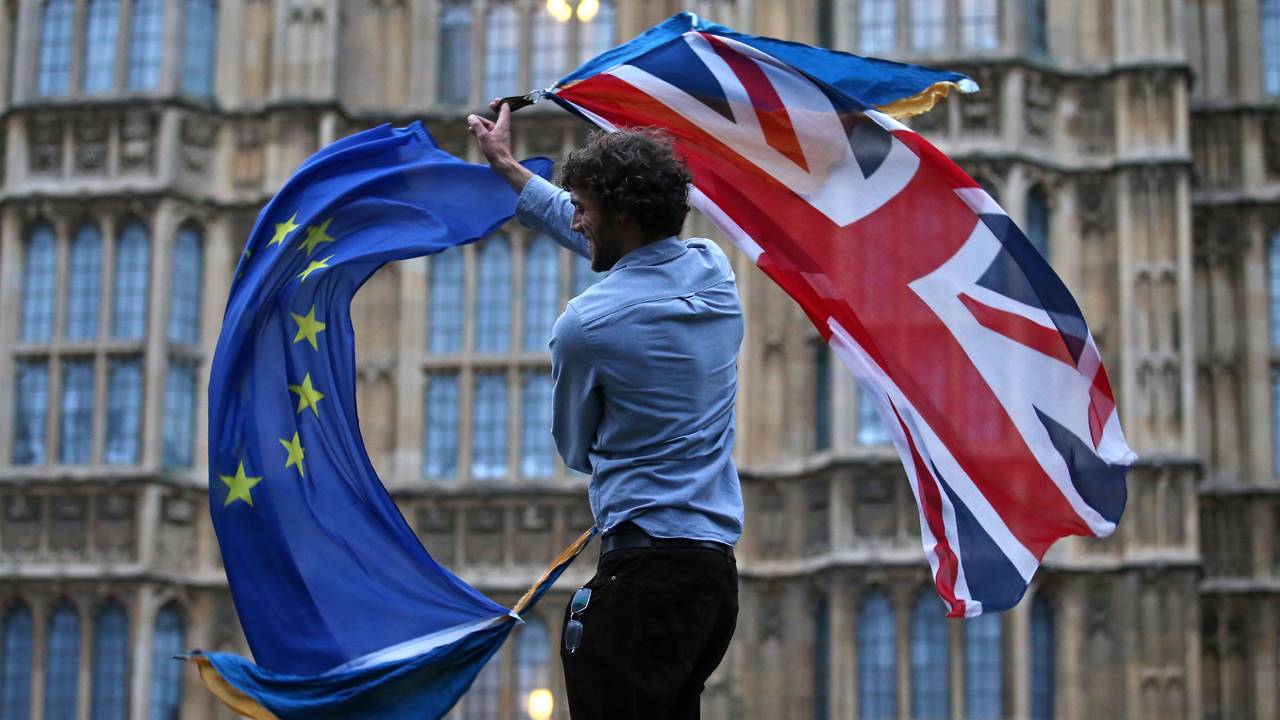 Mann med EU-flagg og britisk flagg