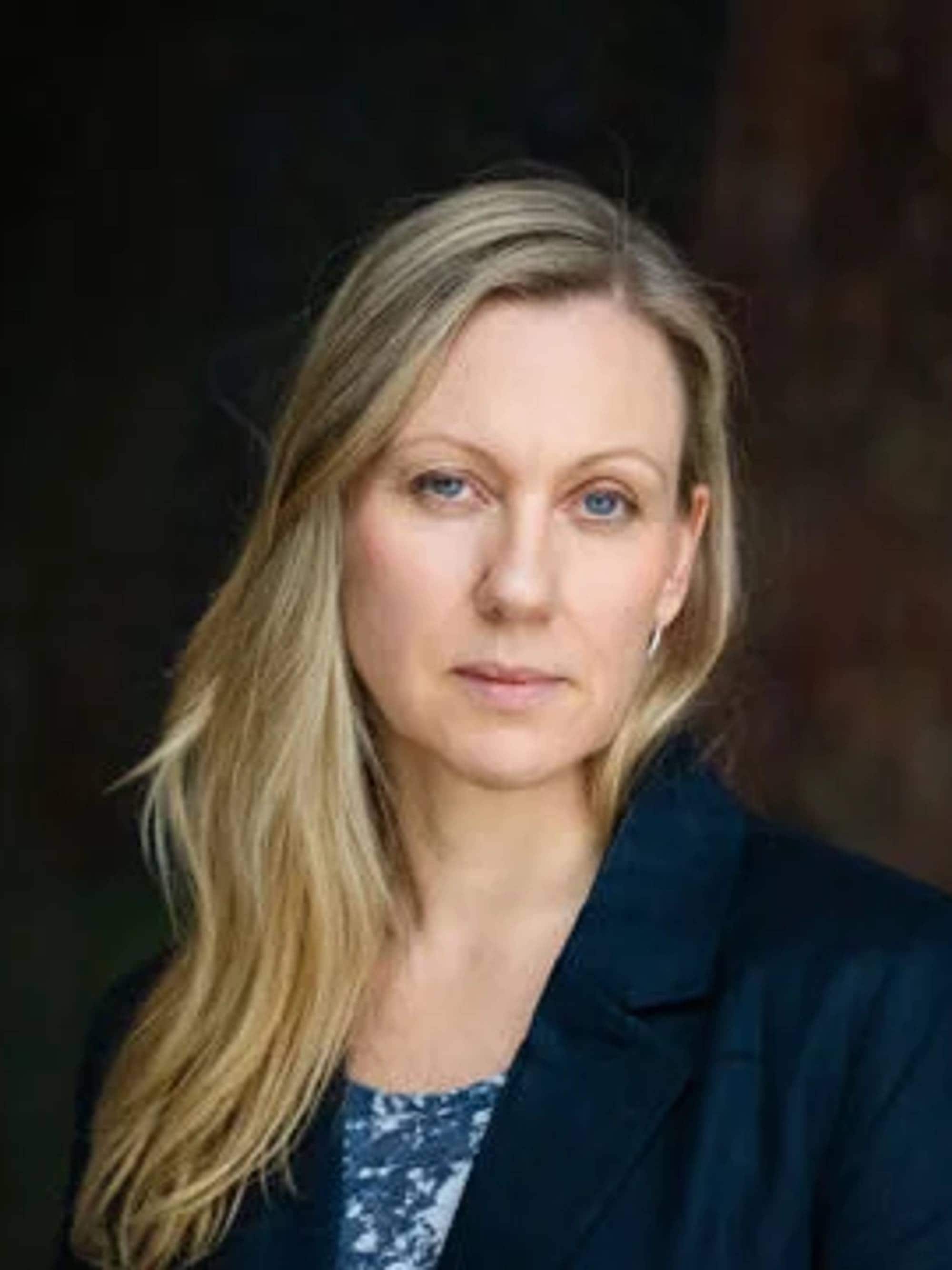 Portrett av kvinne med blondt hår som ser inn i kamera 