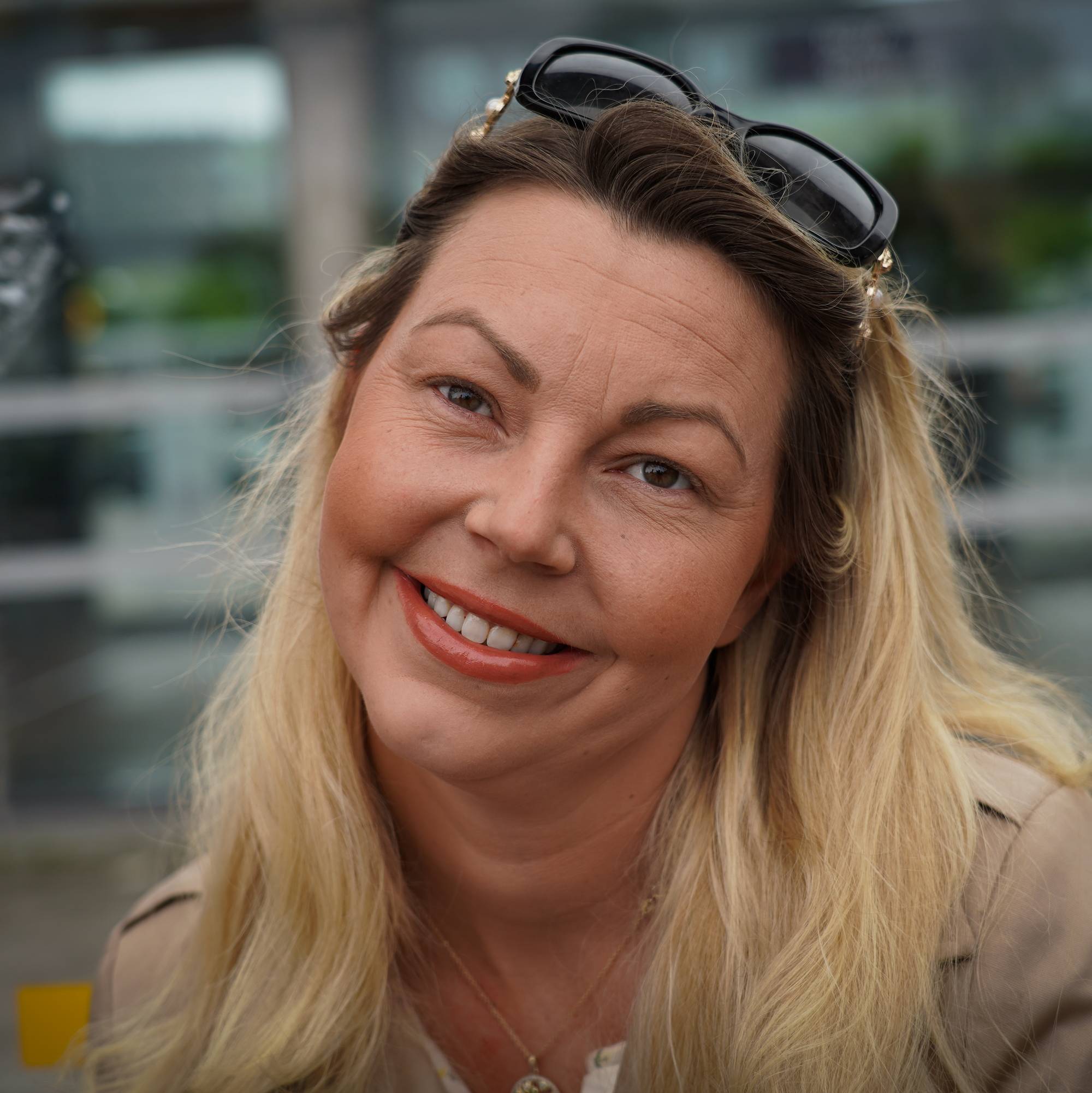 Blid dame med solbriller i et busskur