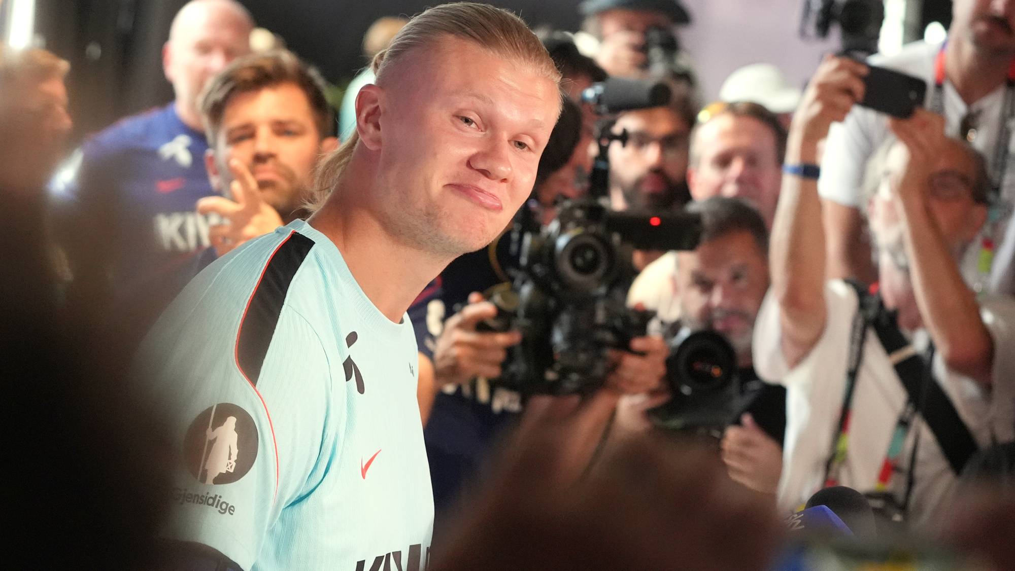 Erling Braut Haaland omgitt av pressefolk med kameraer. (Bildebeskrivelsen er laget av en KI-tjeneste)