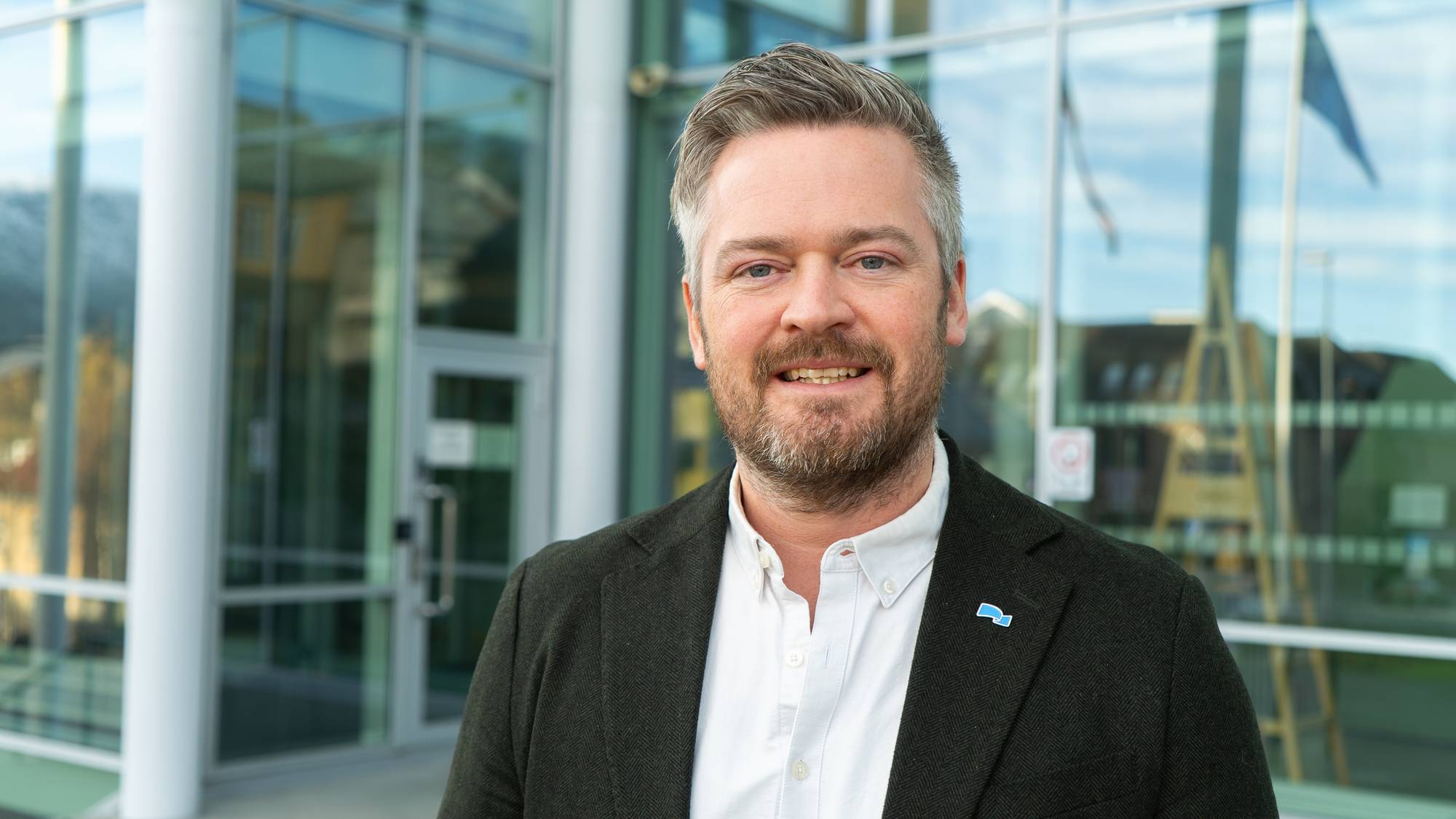 Politikere sitter rundt et stort møtebord i et møterom