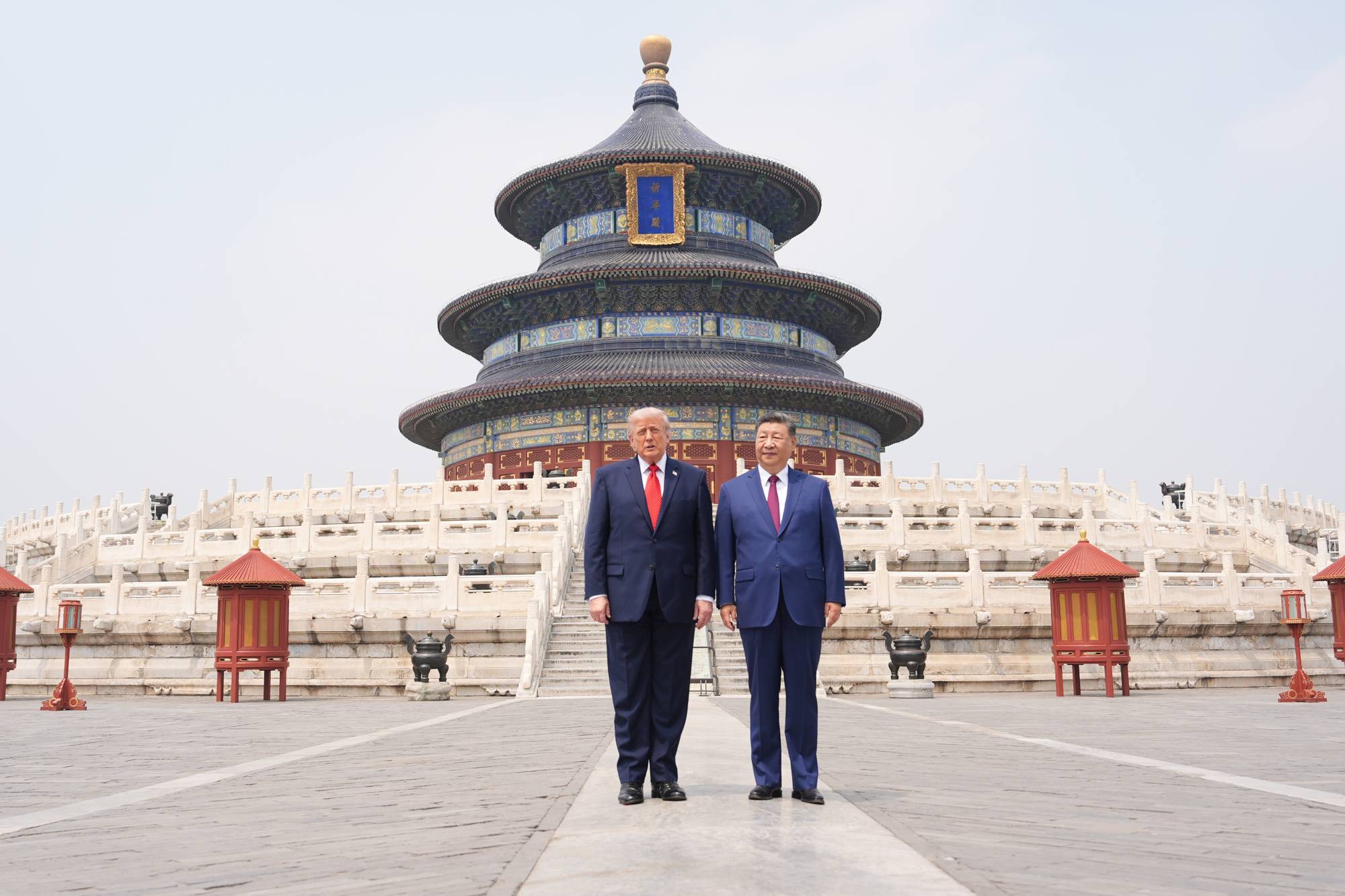 Donald Trump og Xi Jinping står foran tempelet for himmelen. Begge mennene er kledd i dress og slips. Tempelet er en historisk bygning med flere tak og en stor kuppel. (Bildebeskrivelsen er laget av en KI-tjeneste)
