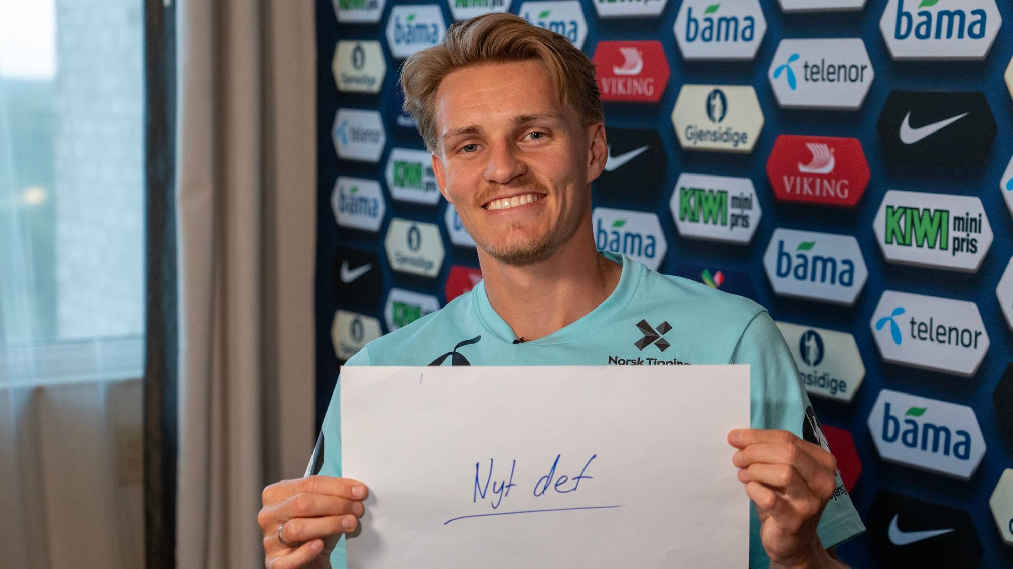 Fotballspiller holder opp en håndskreven teksttekst