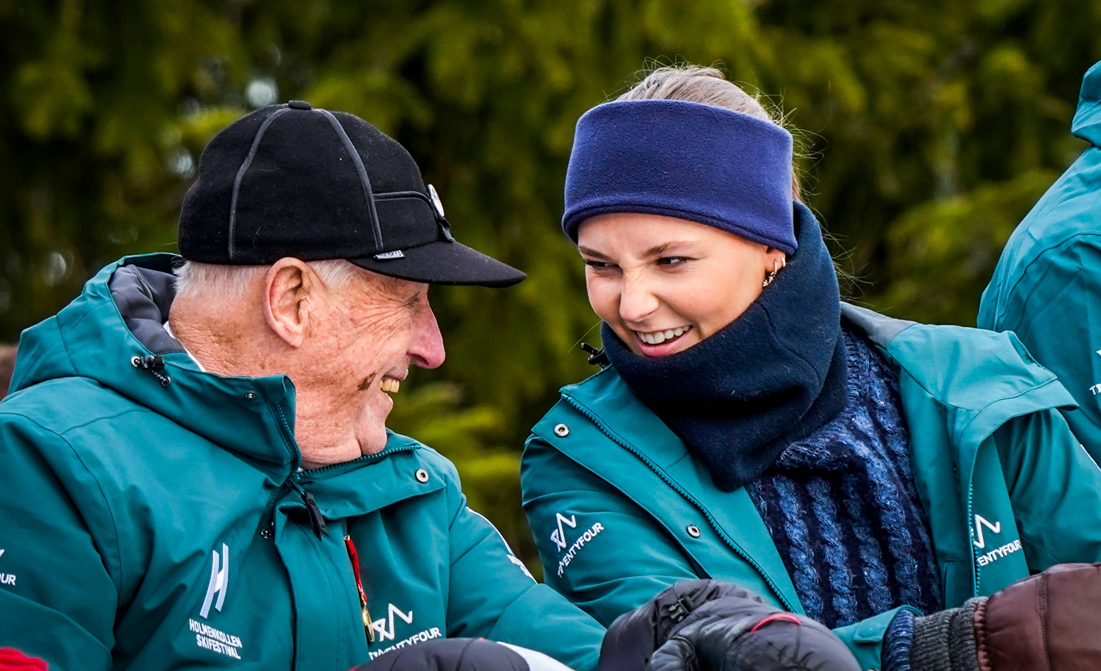 Kong Harald og prinsesse Ingrid Alexandra smiler til hverandre under Holmenkollen skifestival. (Bildebeskrivelsen er laget av en KI-tjeneste)