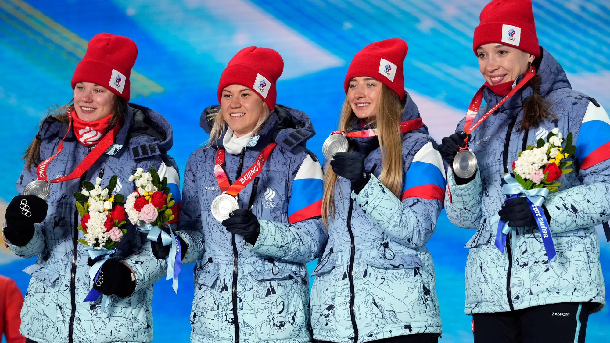 Russiske utøvere med sølvmedaljer på seierspallen under Vinter-OL i Beijing. (Bildebeskrivelsen er laget av en KI-tjeneste)