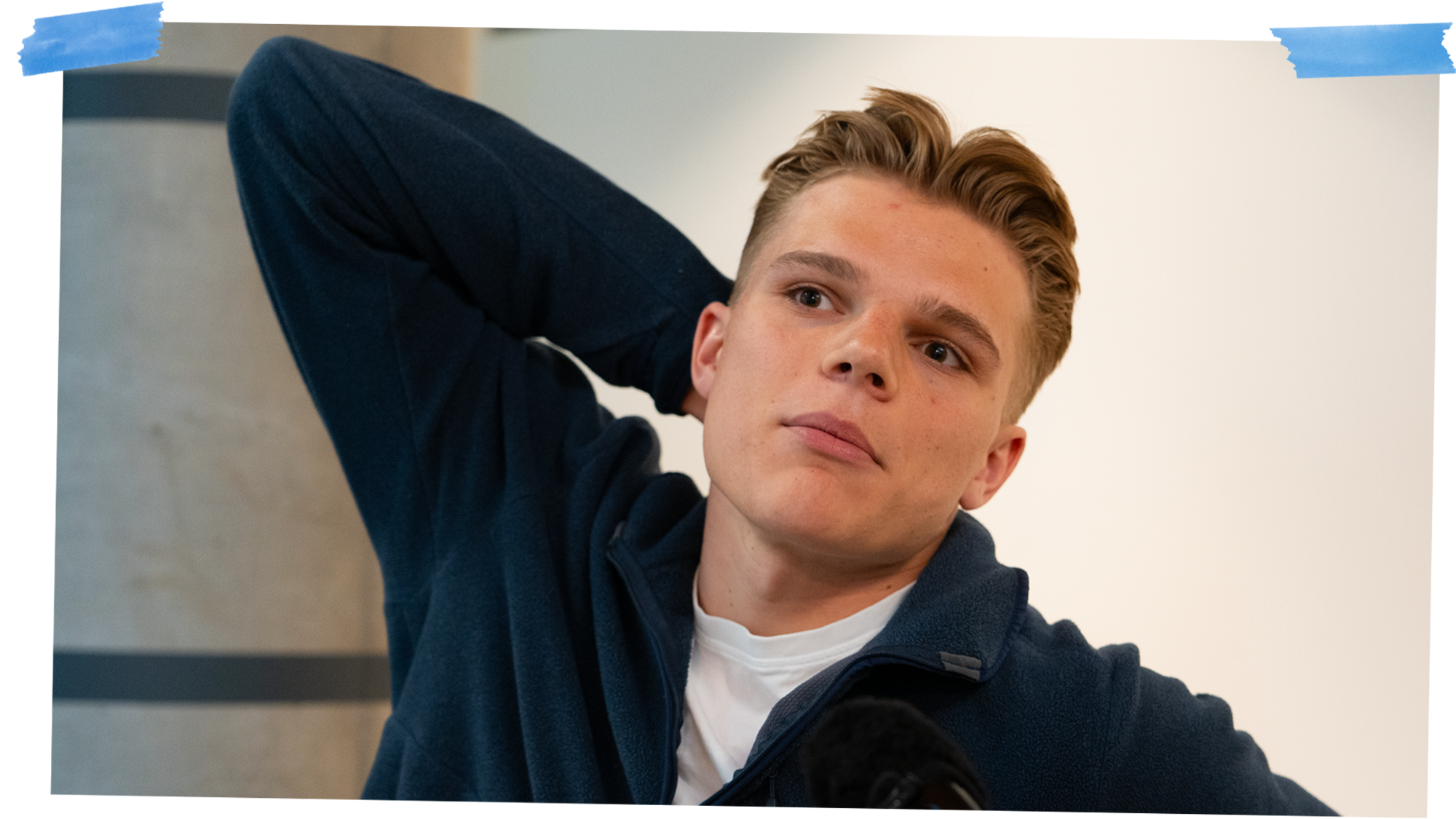 Mann ser til siden og har armen bak hodet.