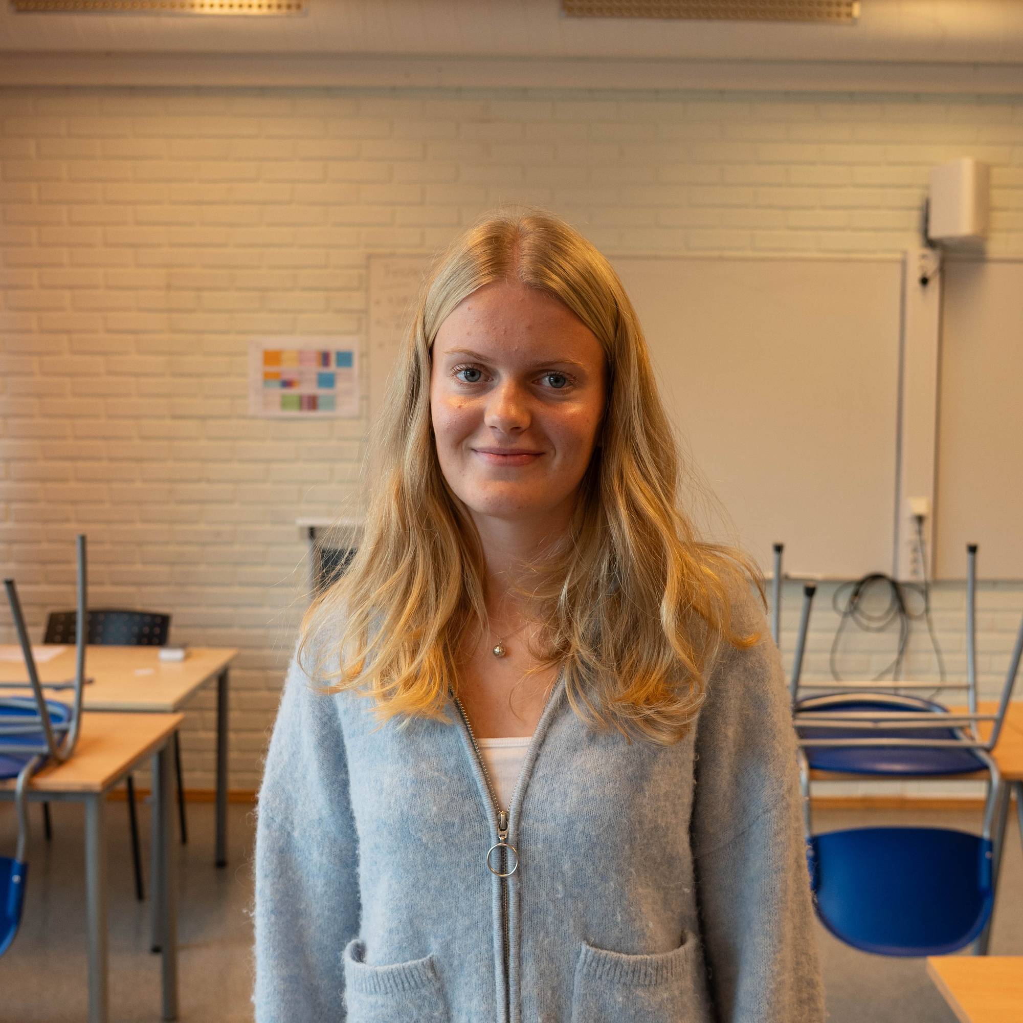 Eleven Annika står på klasserommet og smiler til kamera
