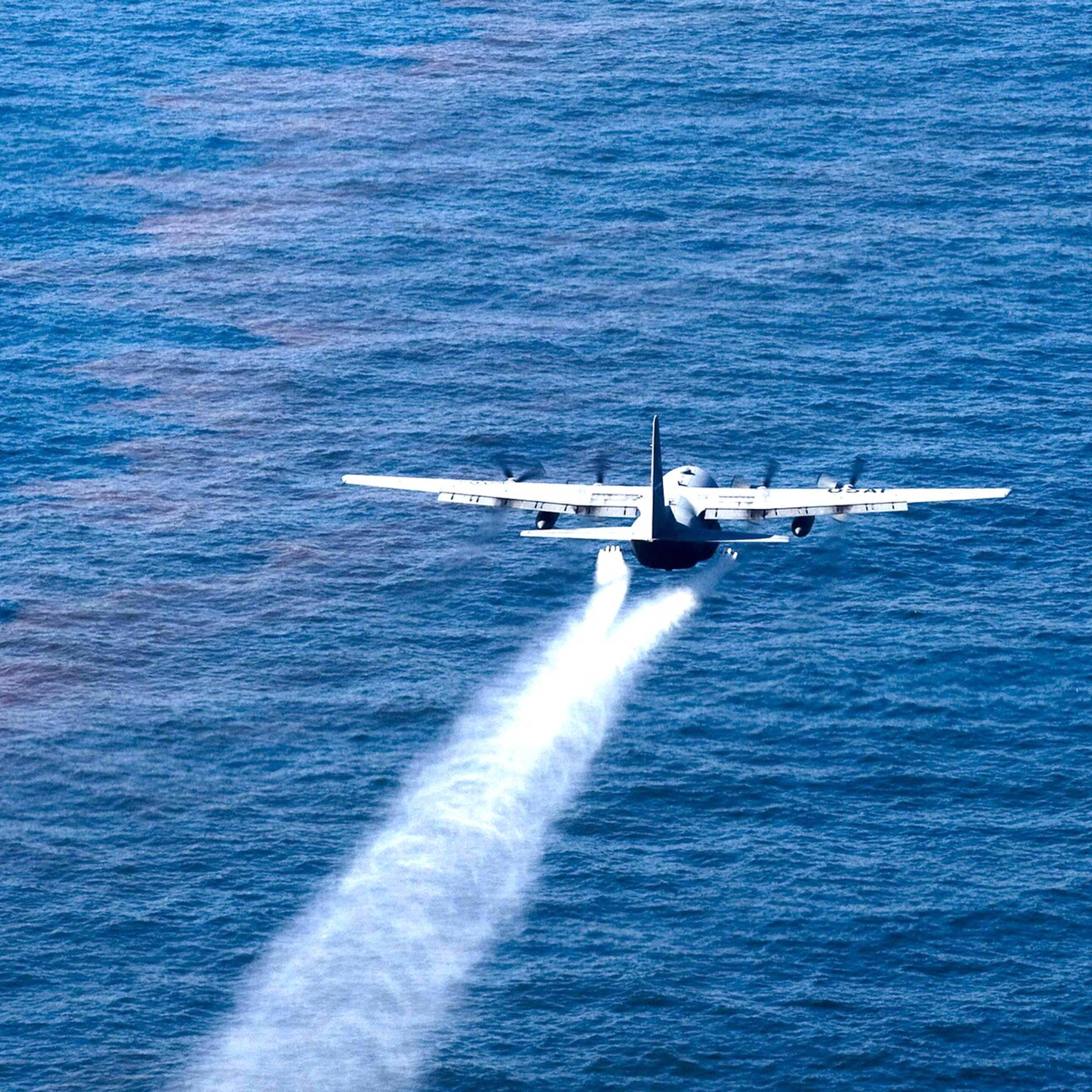 En amerikansk marinefly sprayer et hvit stoff over havet i Mexicogolfen i 2010.