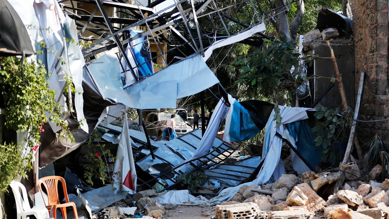 En kvinne bærer torsdag sine eiendeler ut av sitt ødelagte hus i Beirut.