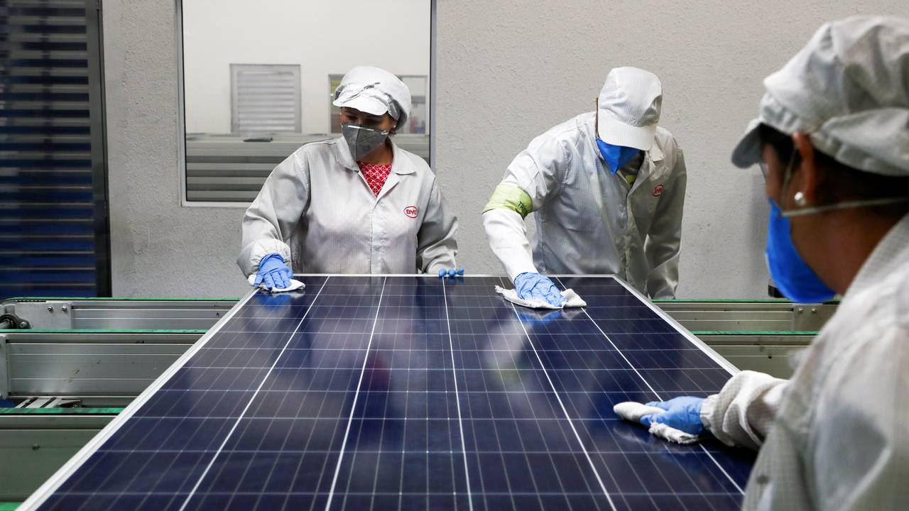 Employees work on a solar energy panel of Chinese solar equipment manufacturer BYD in Campinas