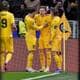 Terje Pedersen / NTB Flere spillere i gule drakter står sammen på fotballbanen etter et mulig mål. En spiller, iført nummer 15, blir gratulert av lagkamerater. I bakgrunnen er det tilskuere og ståplasser på stadion. En hjørneflagget med klubbens logo er synlig til høyre i bildet. (Bildebeskrivelsen er laget av en KI-tjeneste)