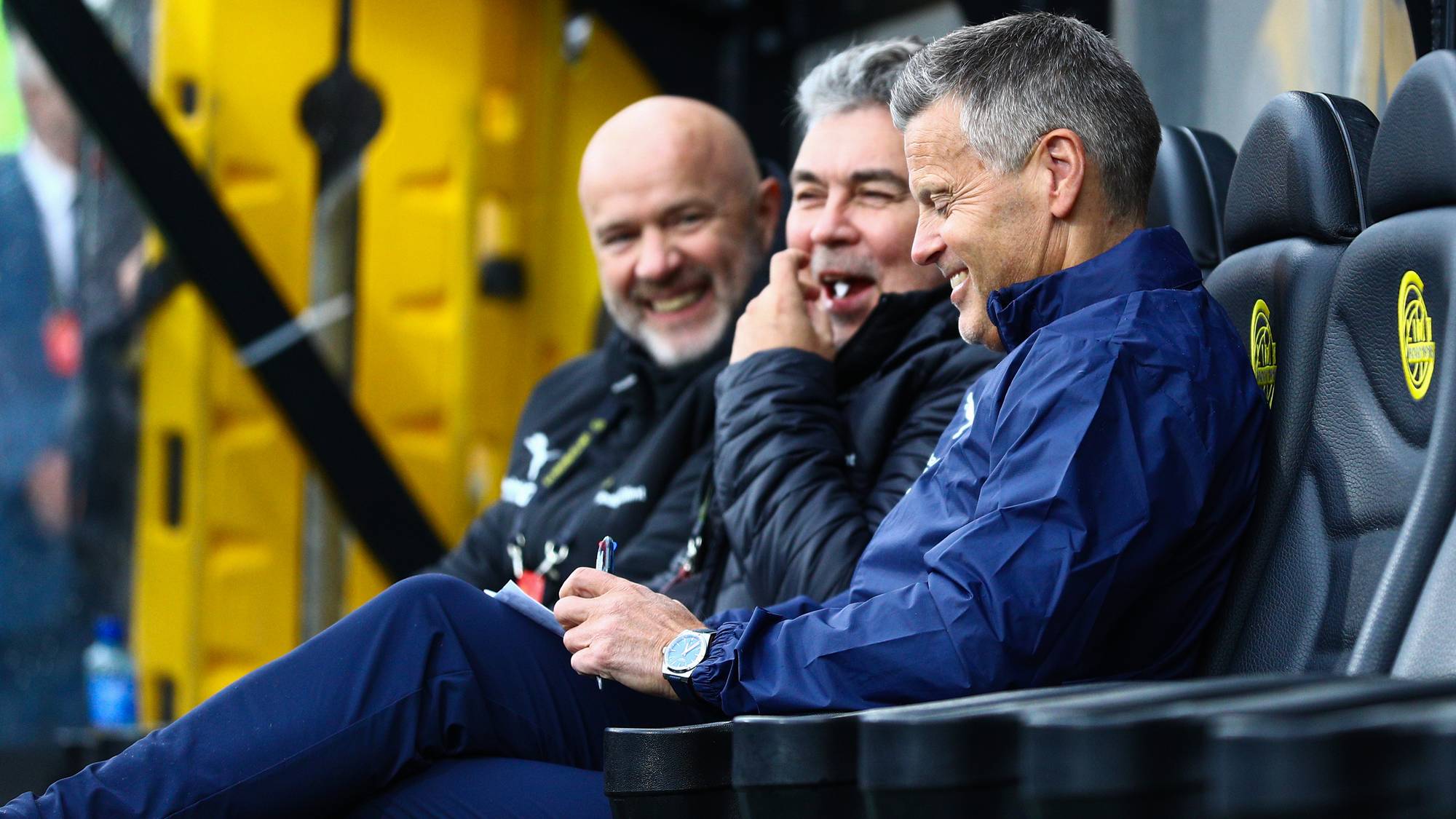 en gruppe menn som sitter på et stadion (Bildebeskrivelsen er laget av en KI-tjeneste)