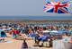 Reuters Strand med turister og et britisk flagg i forgrunnen