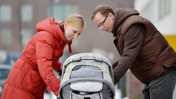  Winter Dressed mother and father looking down  at the baby 