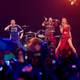 Lisa Leutner / REUTERS,NTB Et band opptrer på en scene med flammekastere og lysshow. En kvinne i rød kjole synger, mens en mann spiller bassgitar. En annen kvinne i rød kjole danser. (Bildebeskrivelsen er laget av en KI-tjeneste)