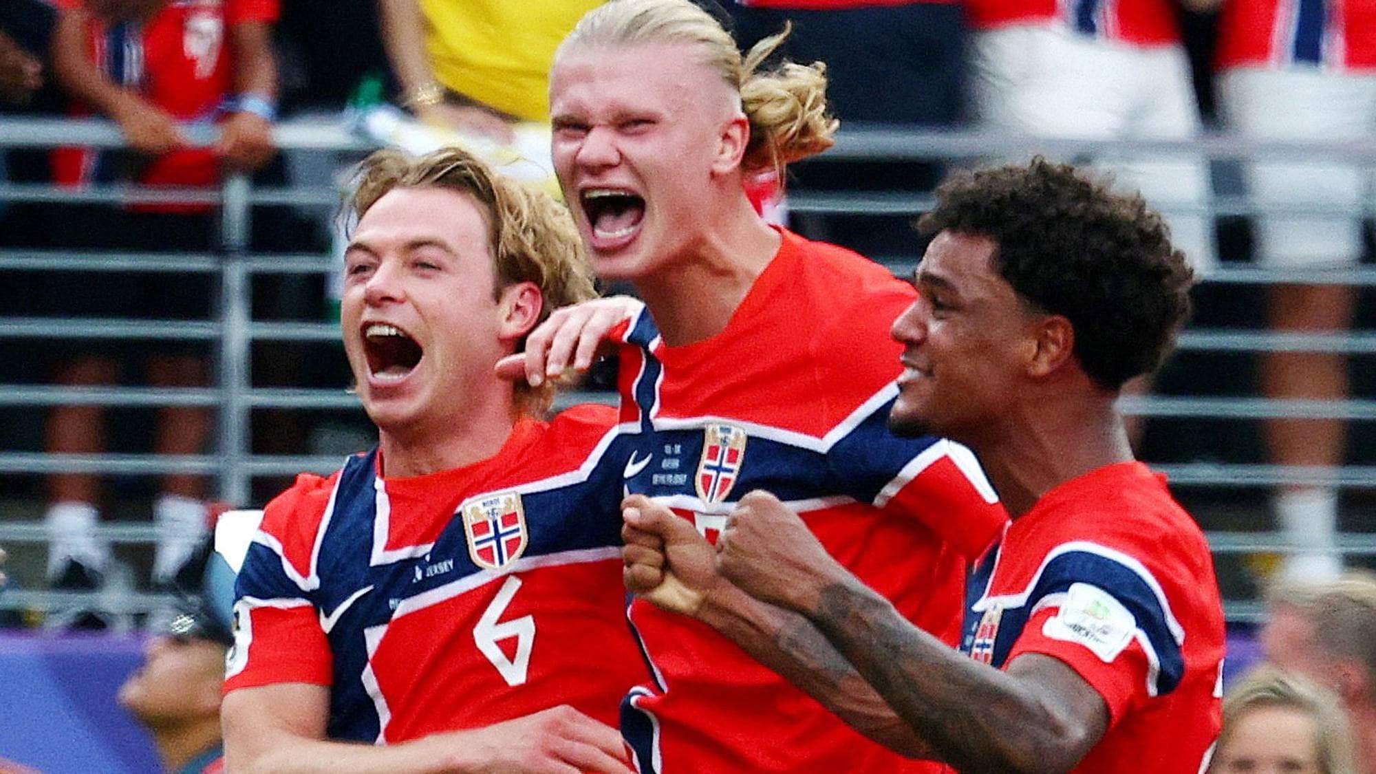 Norske fotballspillere jubler sammen på banen foran et begeistret publikum. (Bildebeskrivelsen er laget av en KI-tjeneste)