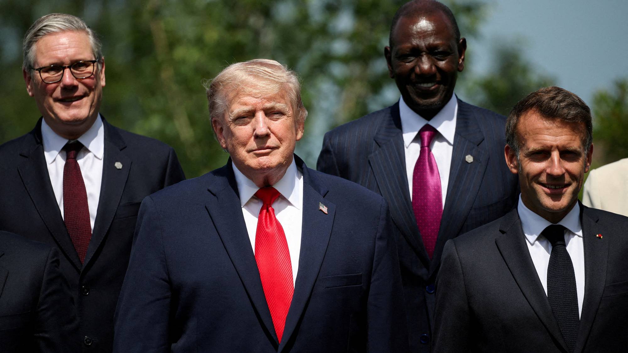 Keir Starmer, Donald Trump, William Ruto og Emmanuel Macron står ved siden av hverandre utendørs. (Bildebeskrivelsen er laget av en KI-tjeneste)