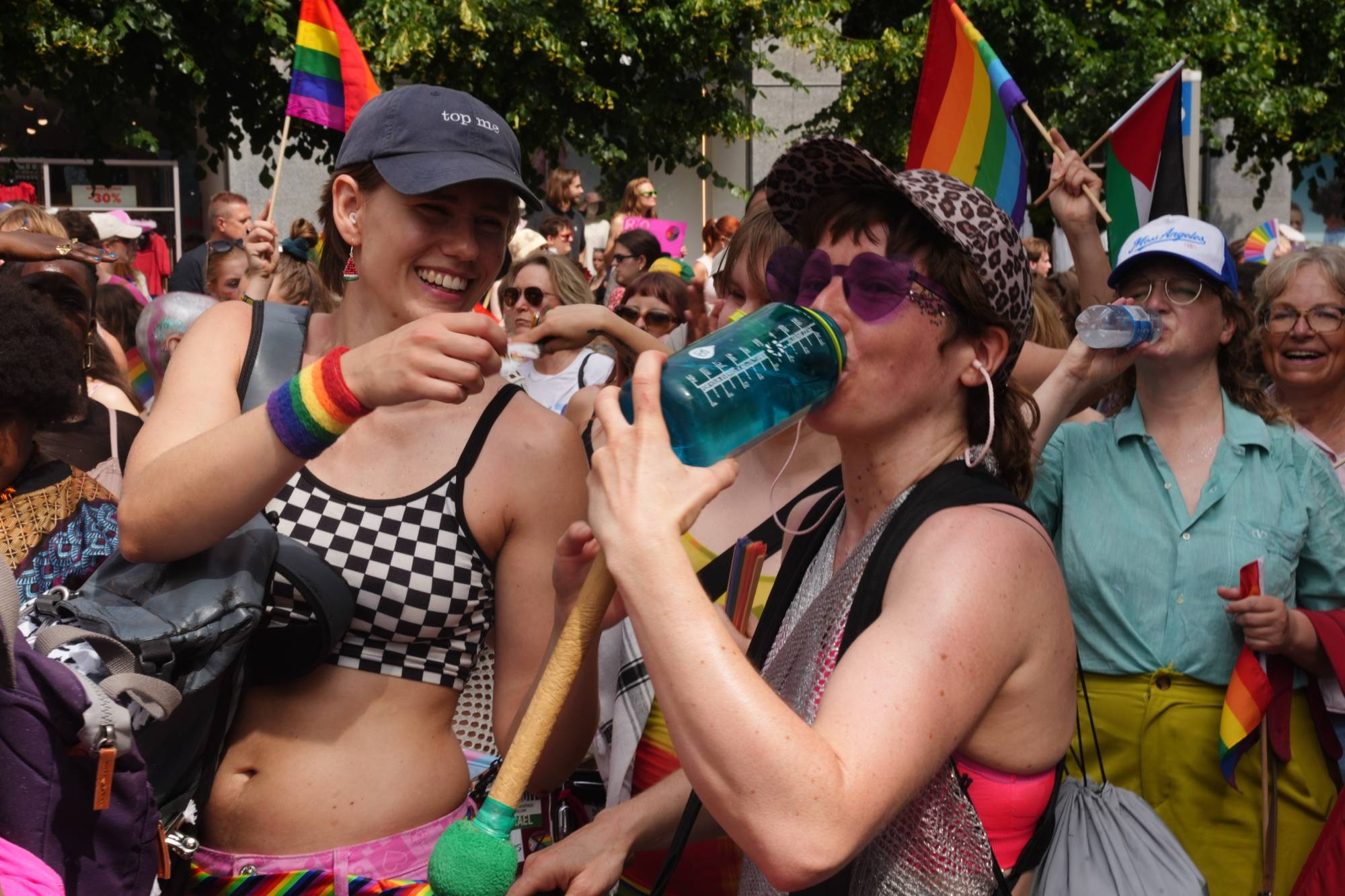 Folk feirer under en pride-parade med regnbueflagg og fargerike klær. (Bildebeskrivelsen er laget av en KI-tjeneste)