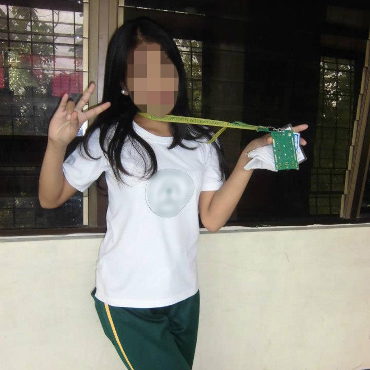 «Lara» vise peace-tegnet med fingrene til kamera mens hun poserer i skoleuniformen. Ansiktet til jenta er anonymisert.