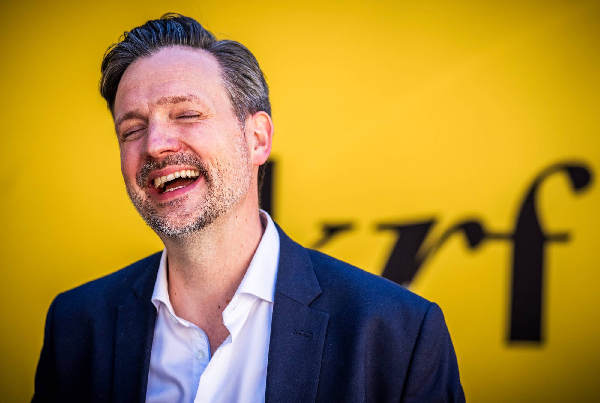KrF-leder Dag-Inge Ulstein ler foran en vegg med KrF-logoen