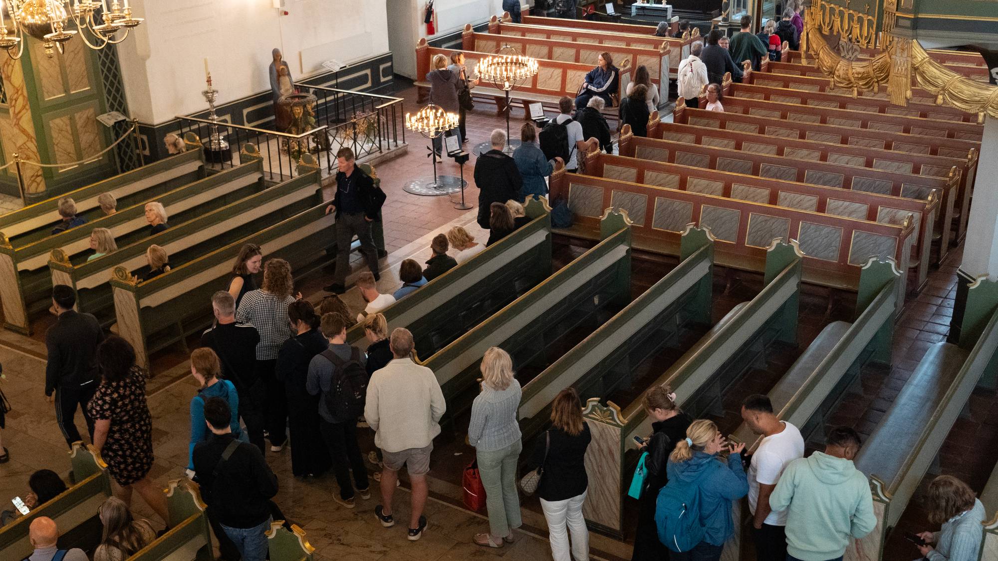 Mennesker i kø inne i oslo domkirke for å tenne lys