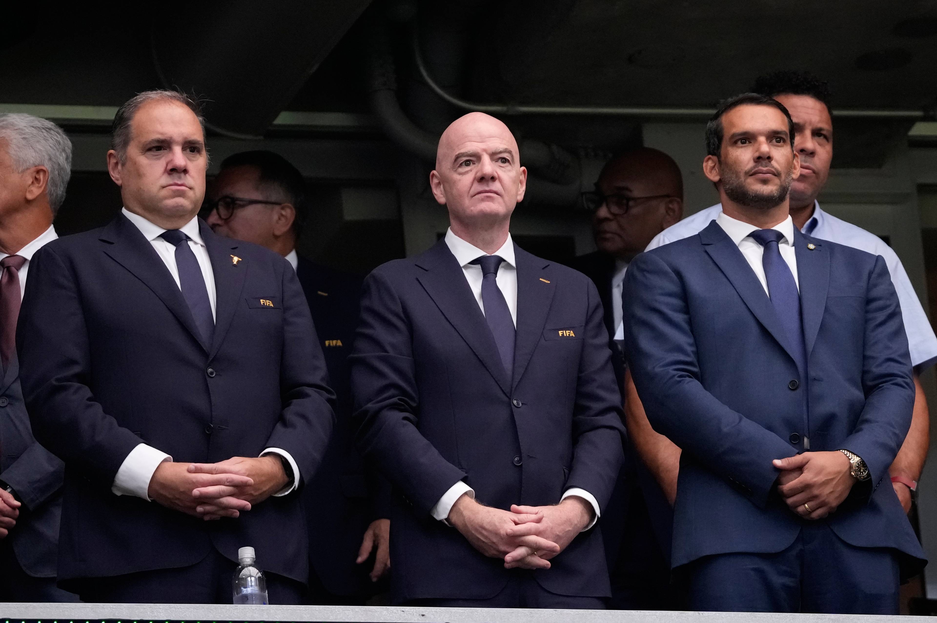 FIFA-president Gianni Infantino og andre menn i dress står saman på ein tribune. (Bildebeskrivelsen er laget av ein KI-teneste)